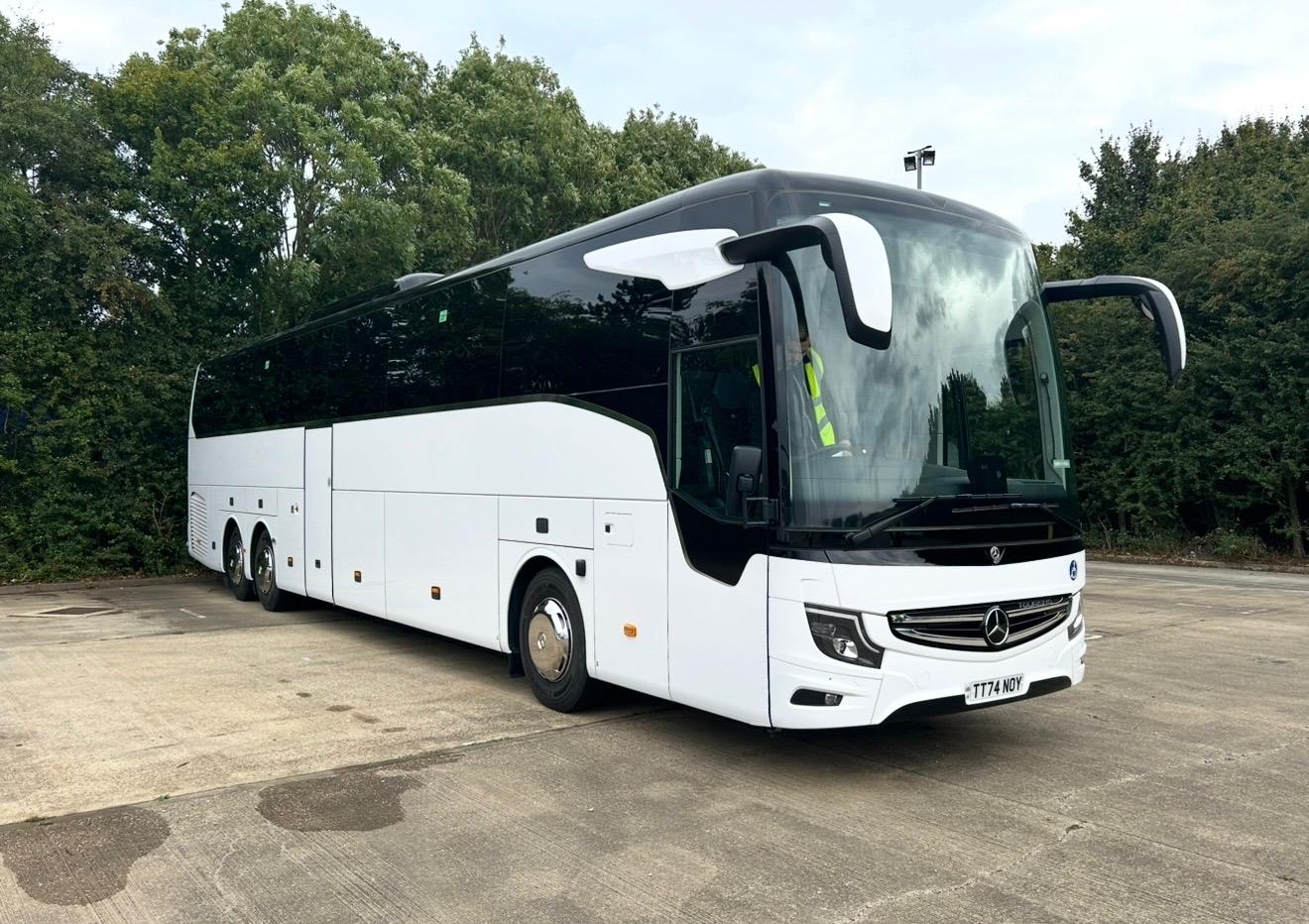 Luxury chauffeur vehicle parked outside modern airport terminal during sunset, representing professional transfer services for business and VIP clients