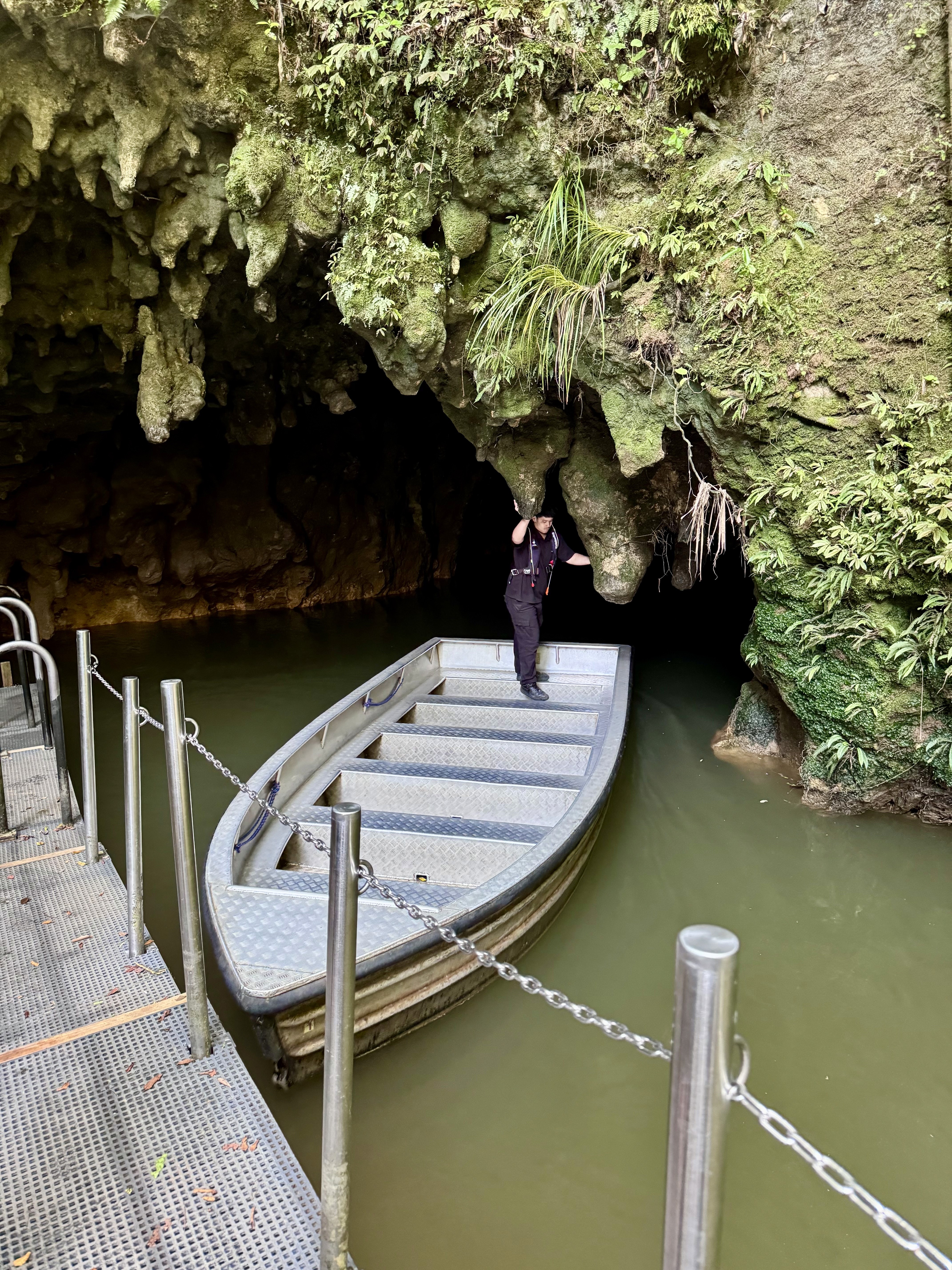 The exit of the Waitomo Caves with the tour boat and the guide in it. 