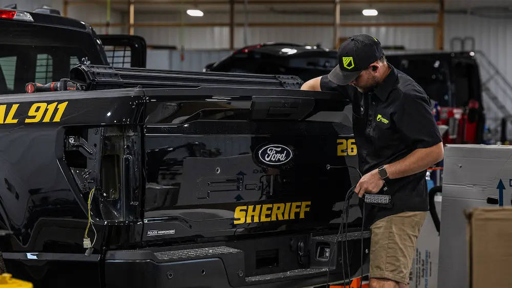 Guardian Fleet Safety technician installing equipment on a law enforcement vehicle during the upfitting process