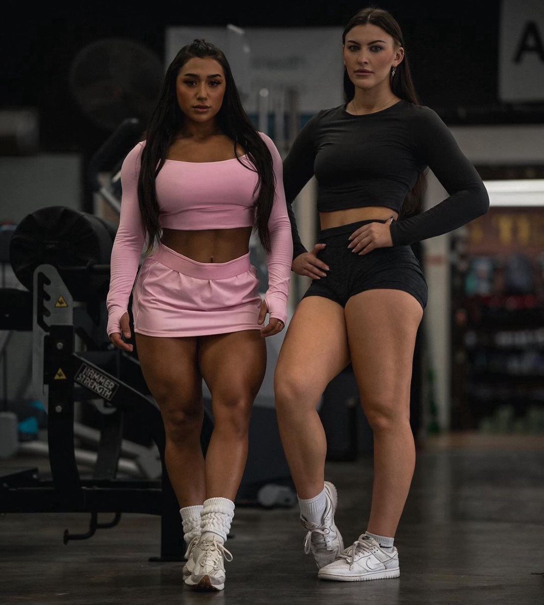 Two female athletes posing on the Big Tex Gym floor