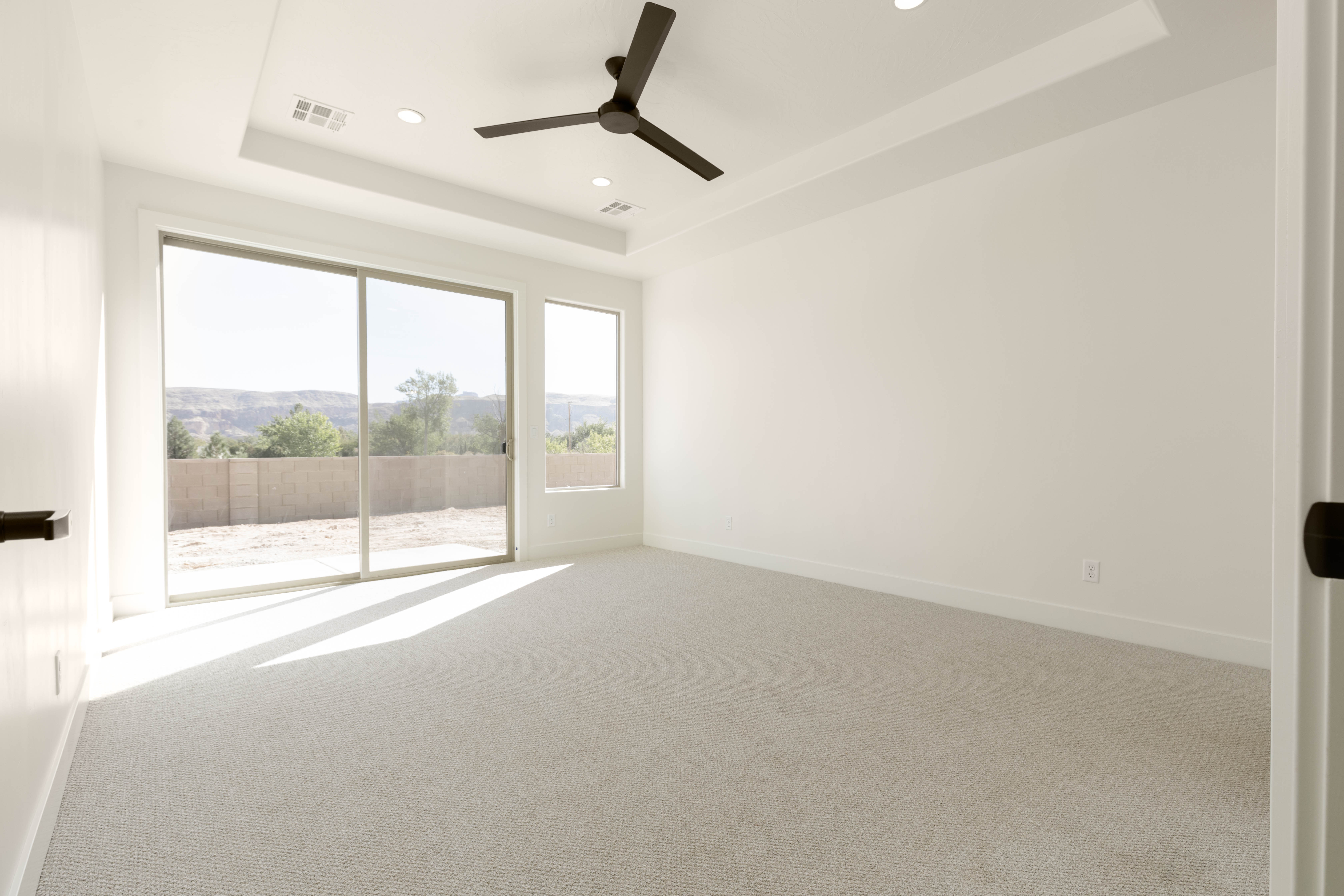 Primary bedroom in The Meridian home in Hurricane Utah with tray ceiling and bright modern finishes.