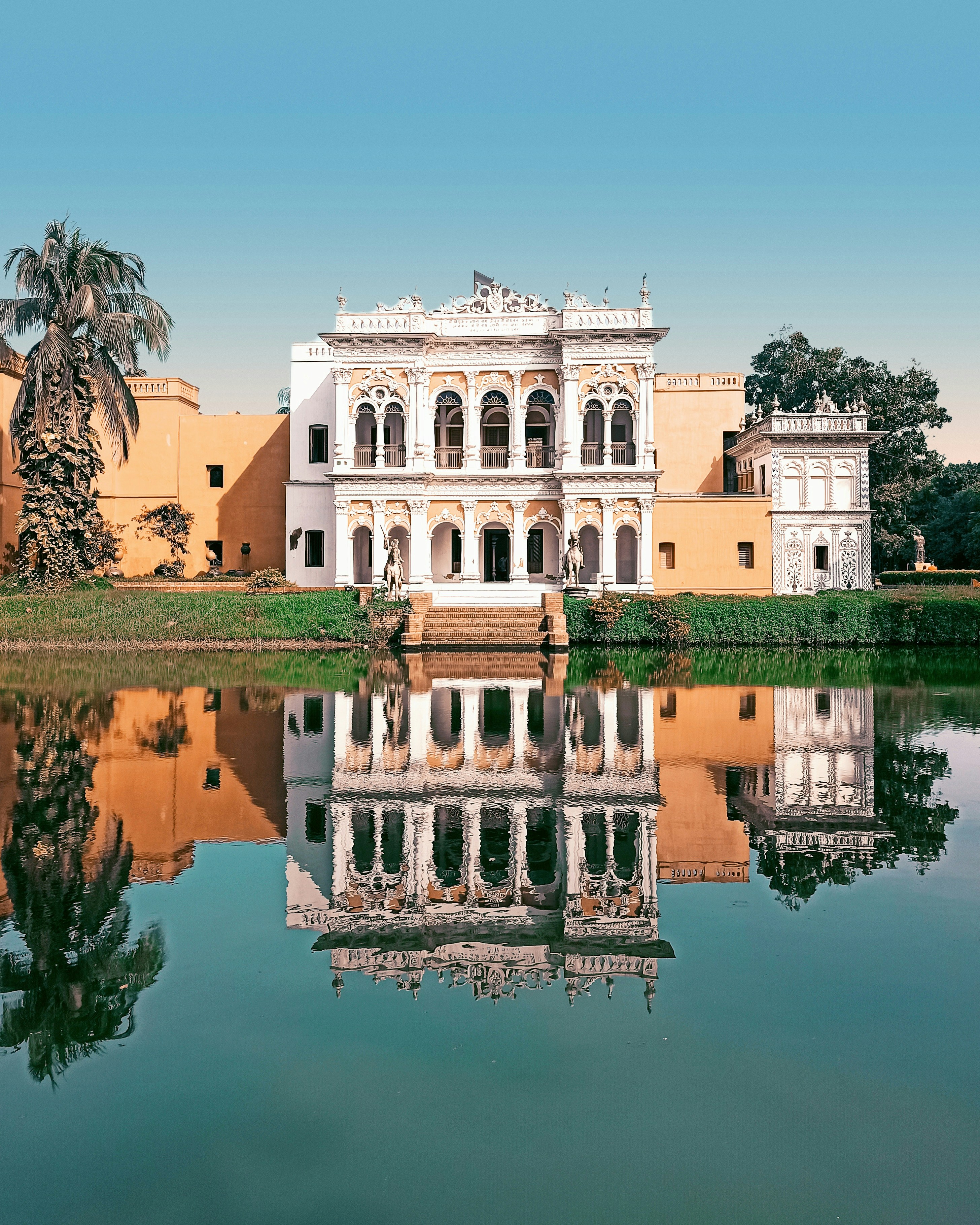a large white building sitting next to a body of water