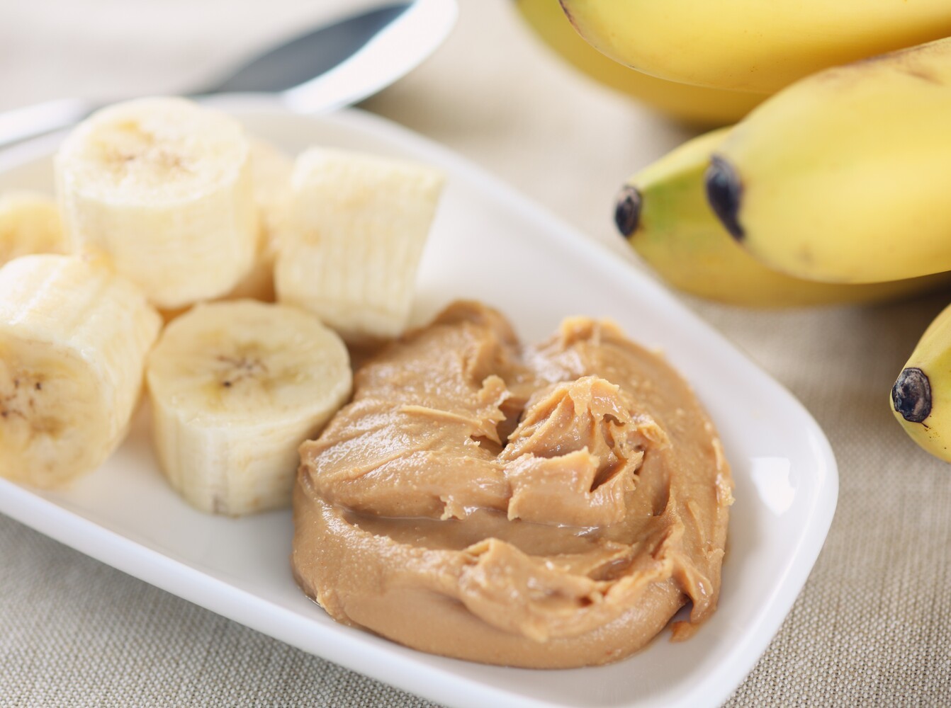 a healthy plate of banana slices and peanut butter for fueling when learning how to run for weight loss