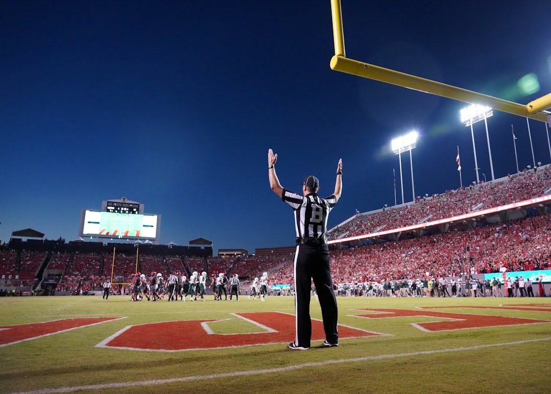 A referee stands on the field at night, overseeing the game during a pivotal moment in Super Bowl history.