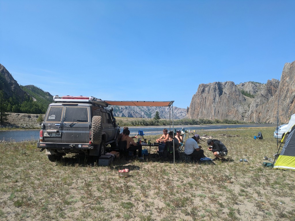 Travelers in Mongolia Camping by a river with cliffs in the Khuvsgul region