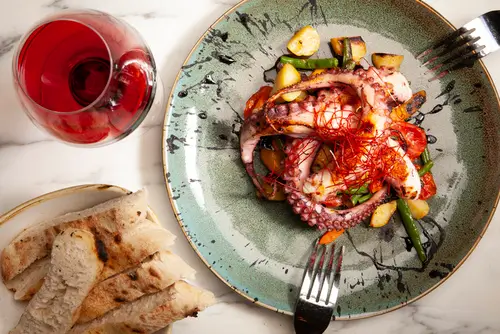 Ensemble de plats & entrées maison : burrata crémeuse des pouilles et poulpe flambé accompagné de légumes méditerranéens