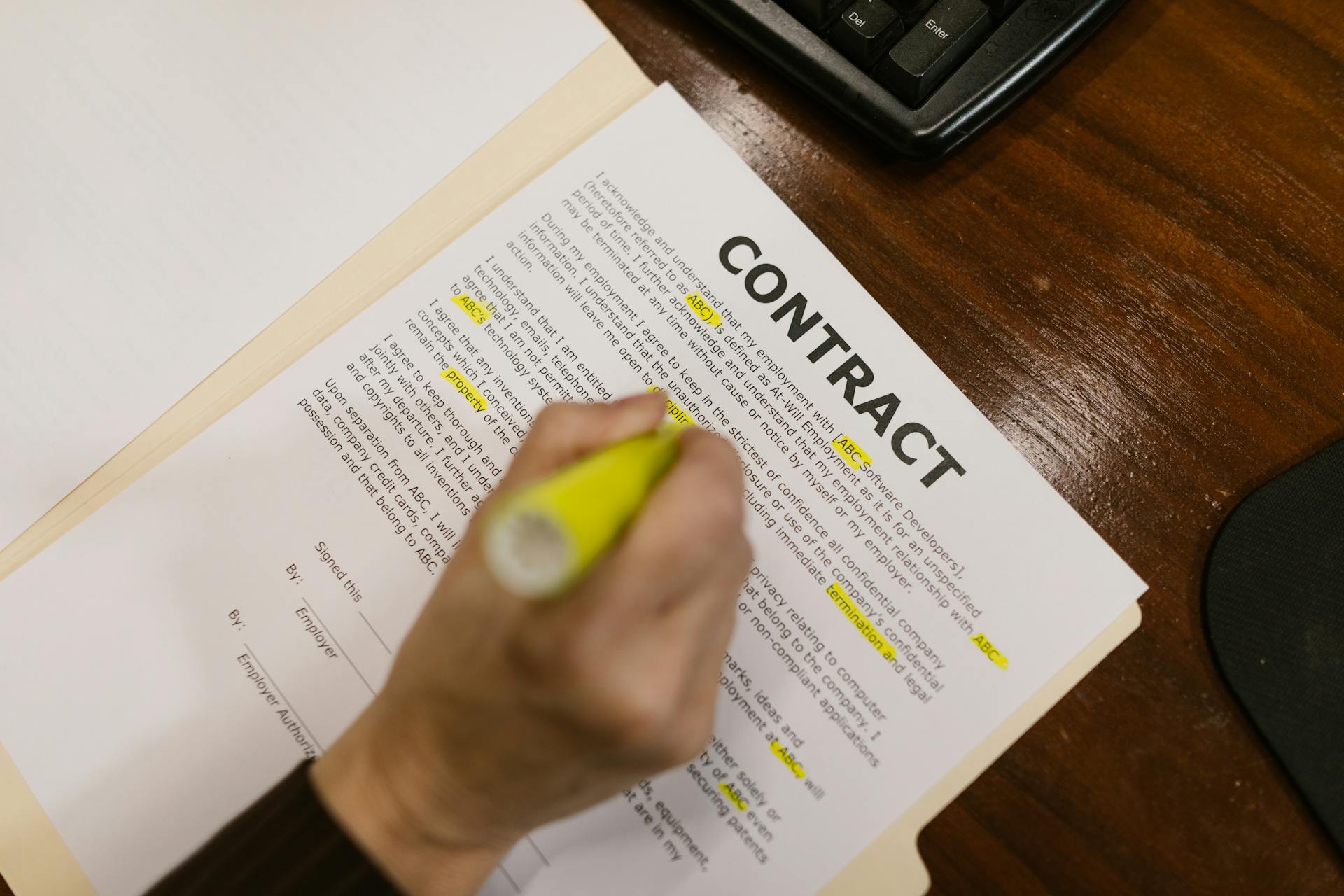 Hands reviewing a contract document on a desk, suggesting procurement and evidence review.