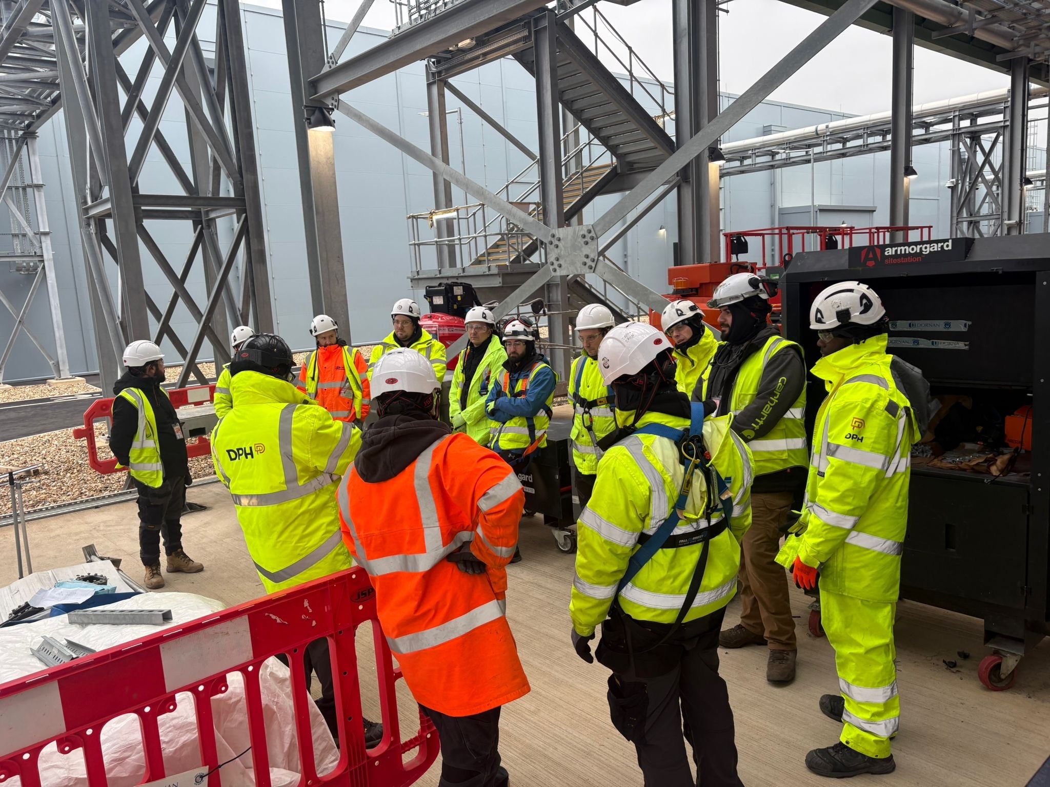 Entrance of a modern glass building with illuminated facade and reflections