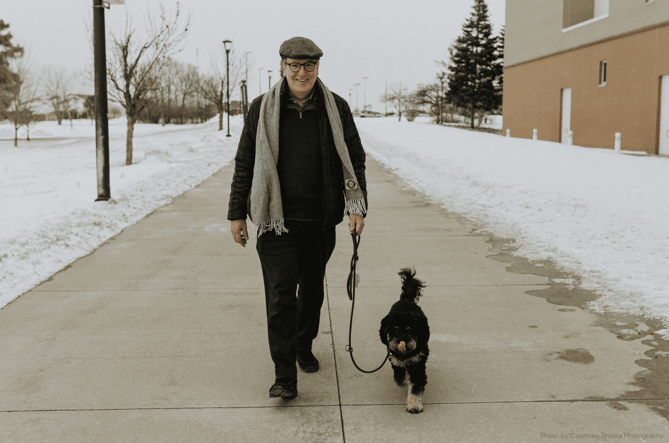 An older man walking his dog