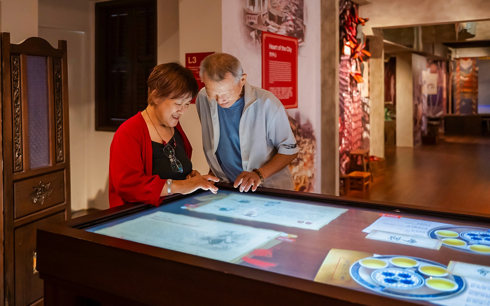 Visitor exploring the Arrival and Settling In exhibit at Chinatown Heritage Centre, showcasing historical artifacts.