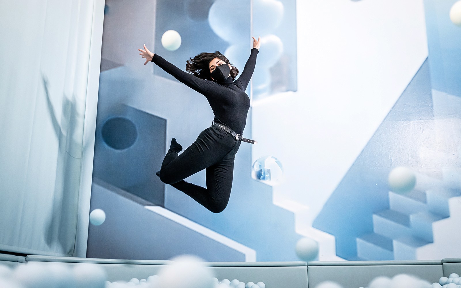 Person som hopper i et rom med geometrisk kunst på Ikono i Madrid.