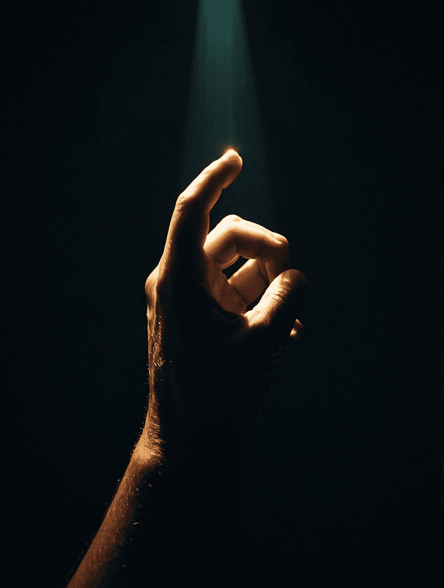 A hand reaching out to a beam of light.