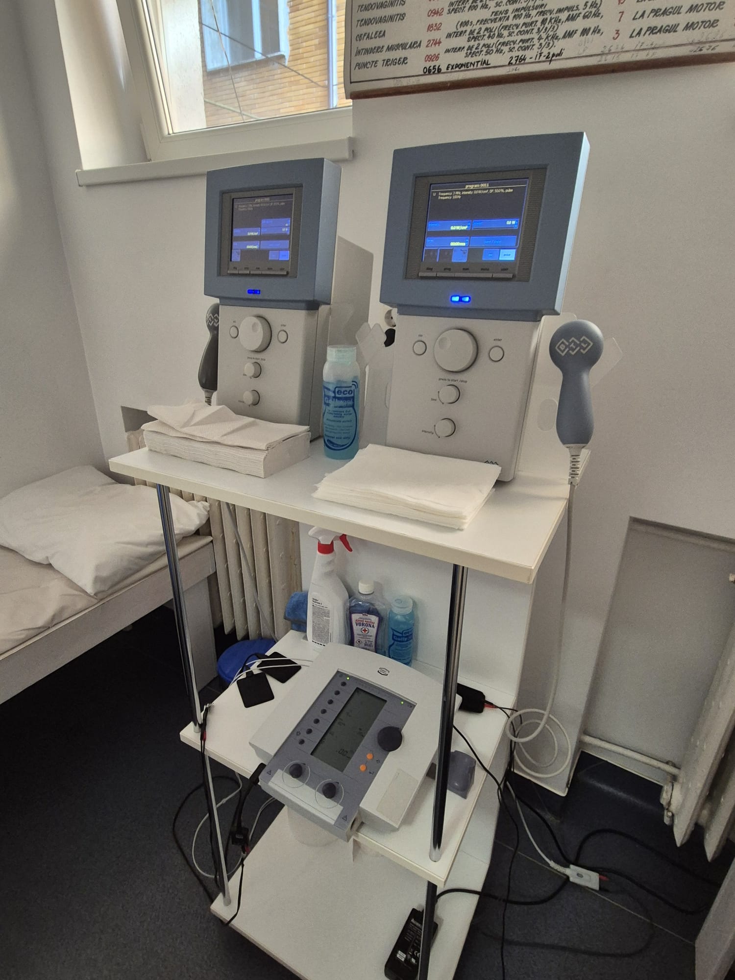 Smiling young woman with long hair standing against a dark green background, holding a finger to her chin.