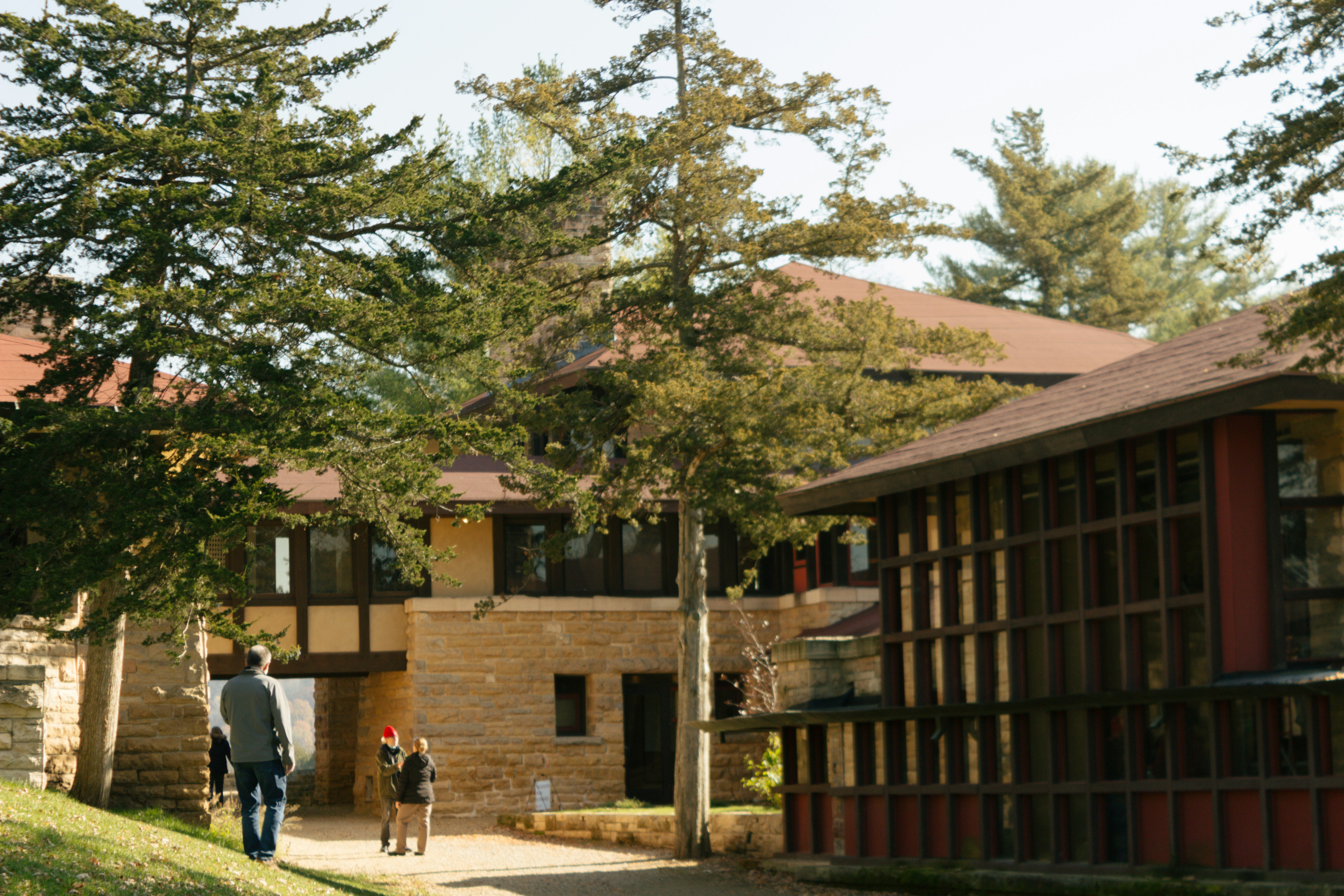 a man and a child walking down a path in front of a building