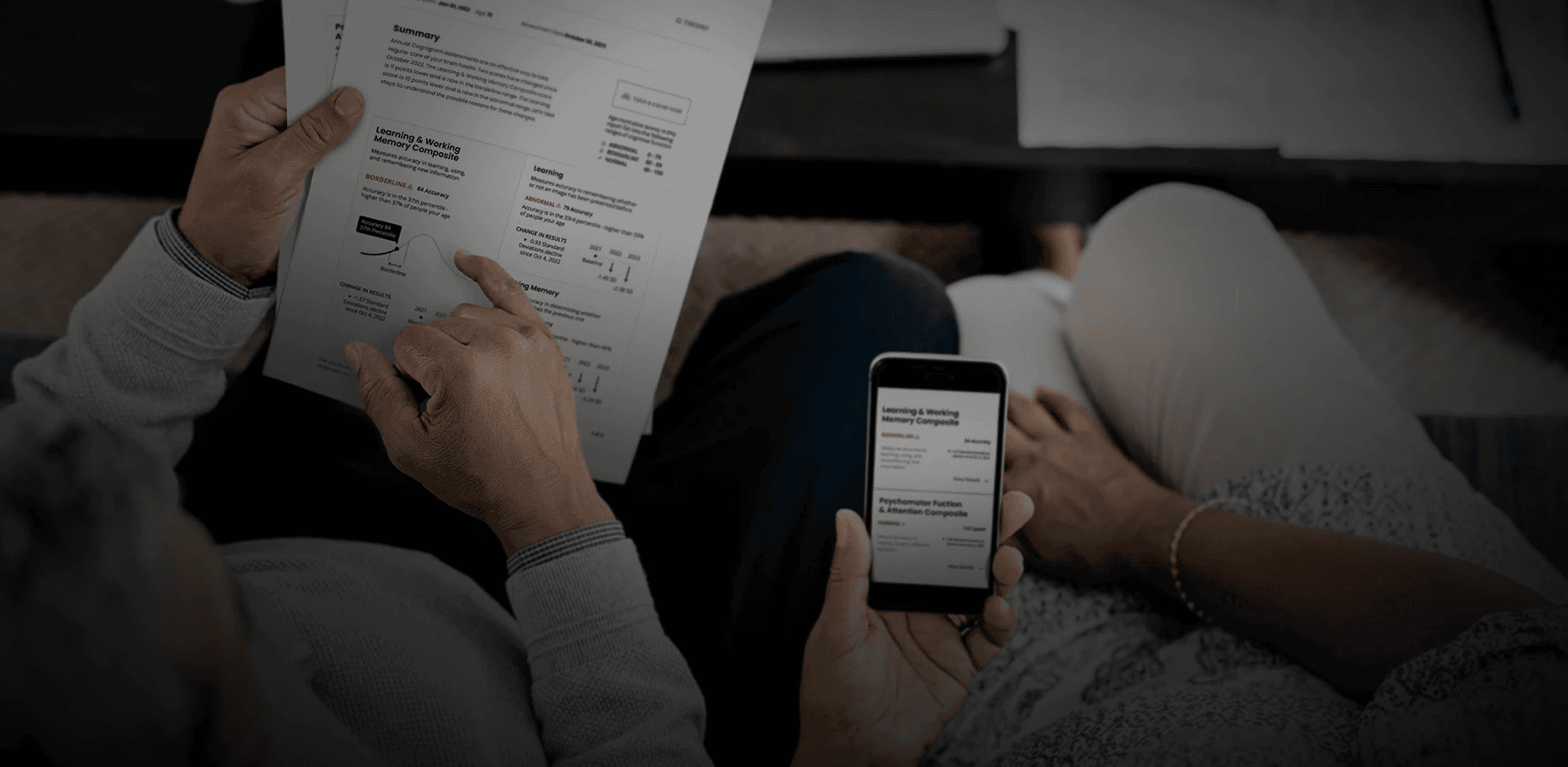 Adult couple review a cognitive assessmen–one on paper, one on their phone