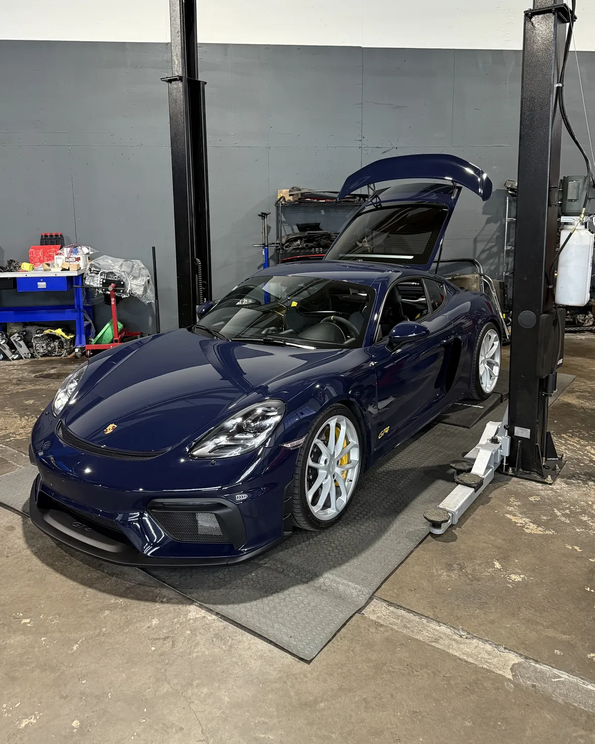 Porsche 718 Cayman GT4 on a lift in the 714 Technik service bay