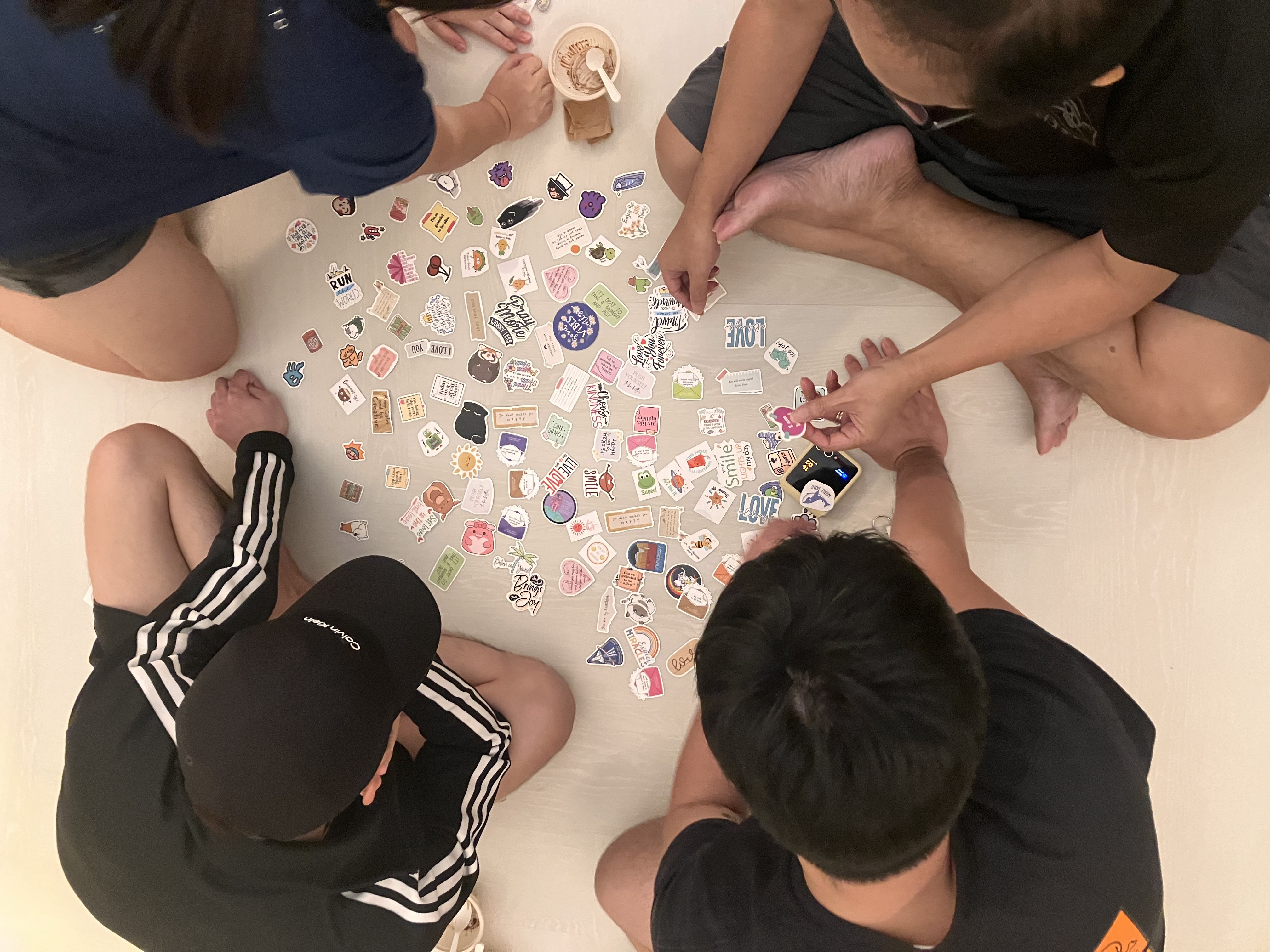A smiling woman with her arms crossed, standing against a dark green background. She has long, dark hair.