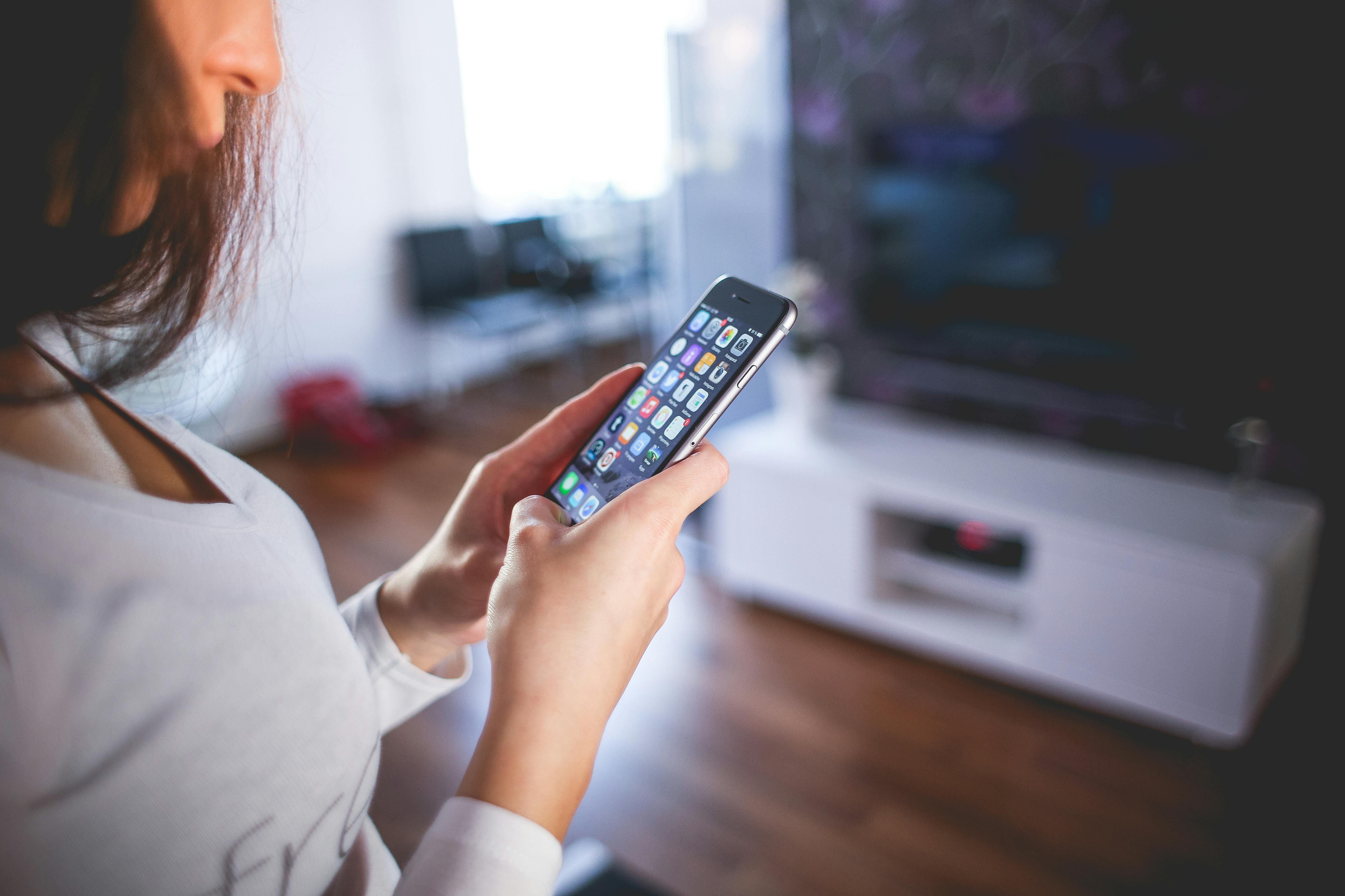 Utente con telecomando davanti alla TV: scelta e fruizione di contenuti multimediali
