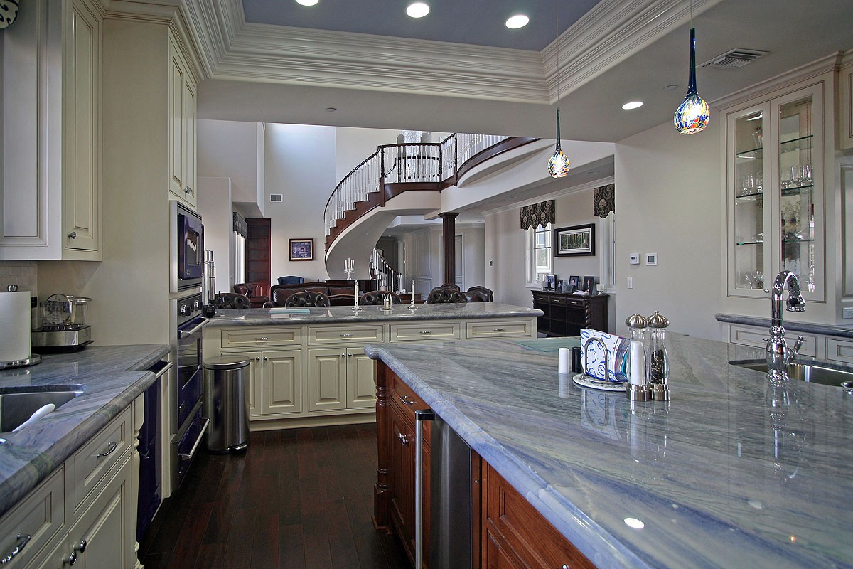 View of the modern kitchen with a large island, featuring cobalt blue appliances and rustic design accents.