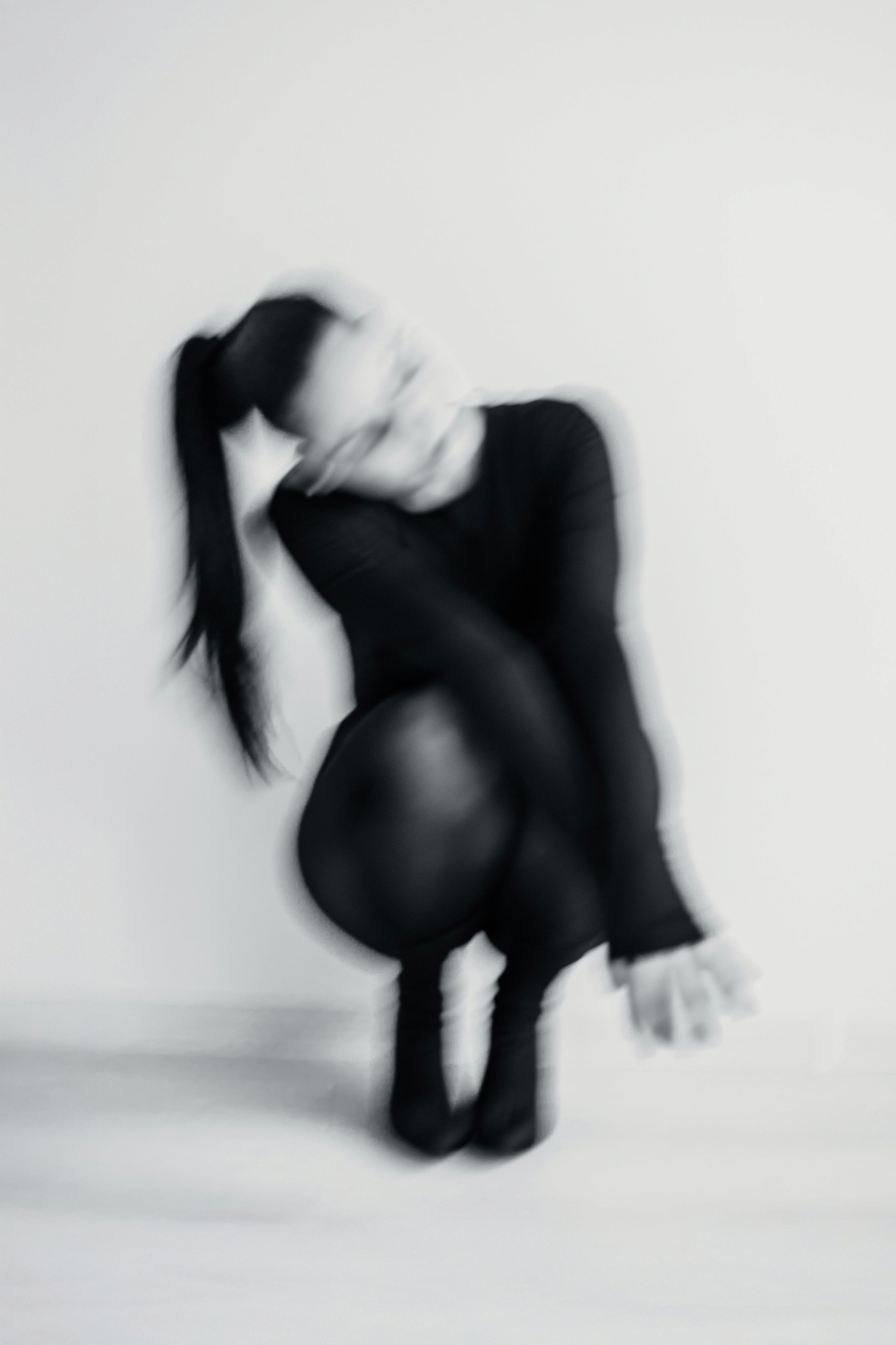 Blurred figure of a person in a black outfit.