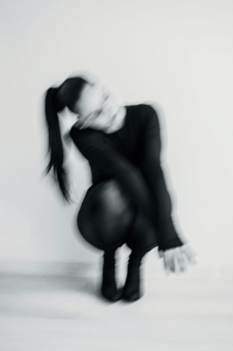 Blurred figure of a person in a black outfit.