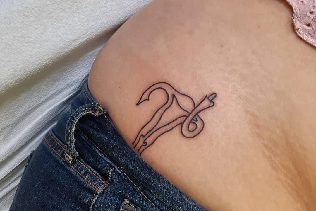 Black-and-grey outline dagger and bird tattoo on a ribcage