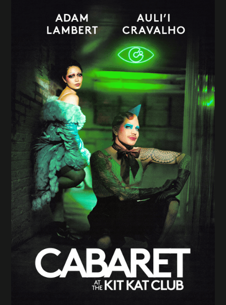 Cabaret at the Kit Kat Club on Broadway. In a green lit alley with the Kit Kat Club logo in a neon light in the top right.  Auli'i Cravalho (as Sally Bowles) leans against the wall, one foot against the wall. Adam Lambert (as the Emcee) squats in the center of the alley in a puddle. He is topless, wearing a tie and a birthday hat.