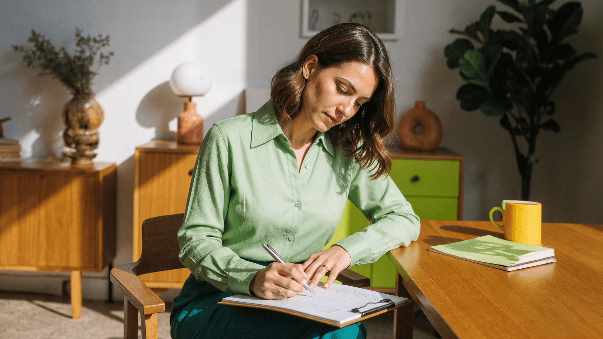 Mulher sentada à mesa preenchendo checklist de planejamento e organização, representando rotinas administrativas e estratégias de SEO local em clínicas com apoio da Tivita.