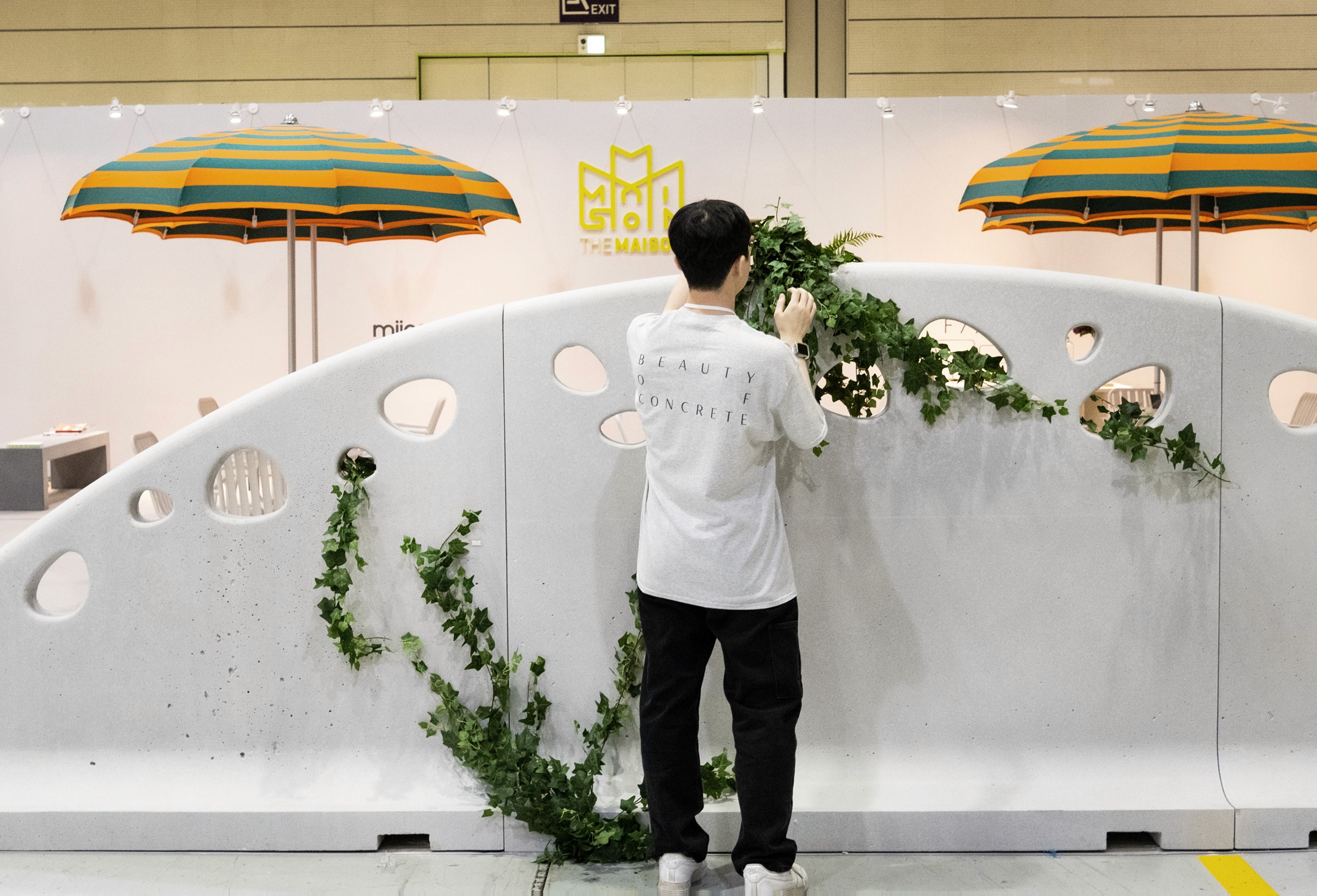 Stacked glass cube with layered translucent liquid on a concrete floor—minimal studio sculpture against a white wall.