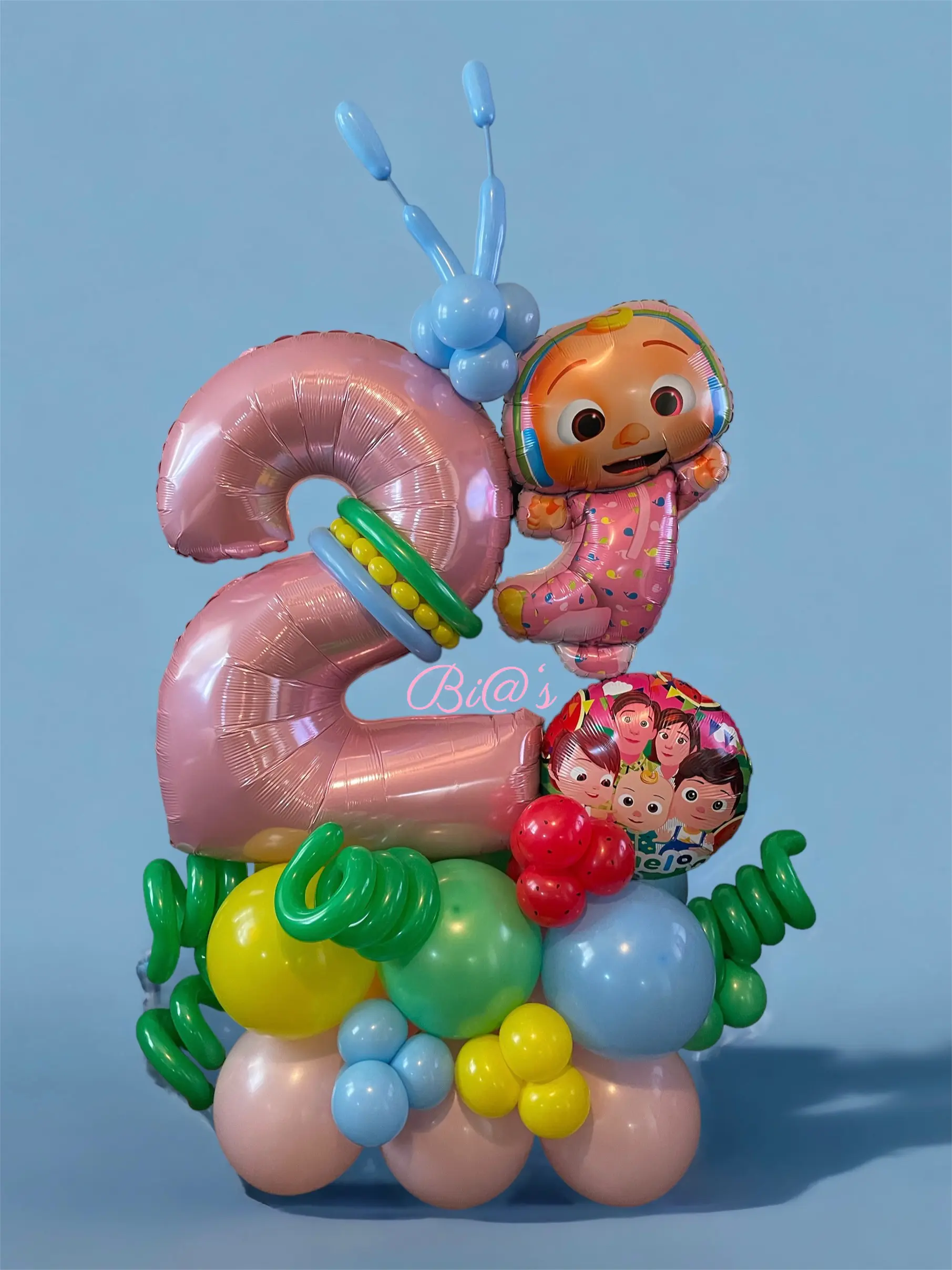 Colorful children’s balloon display with a large number “2” and playful character-themed elements in pastel hues. A lively and fun arrangement that captures the joy of childhood. Susa’s Sweets & Balloons.