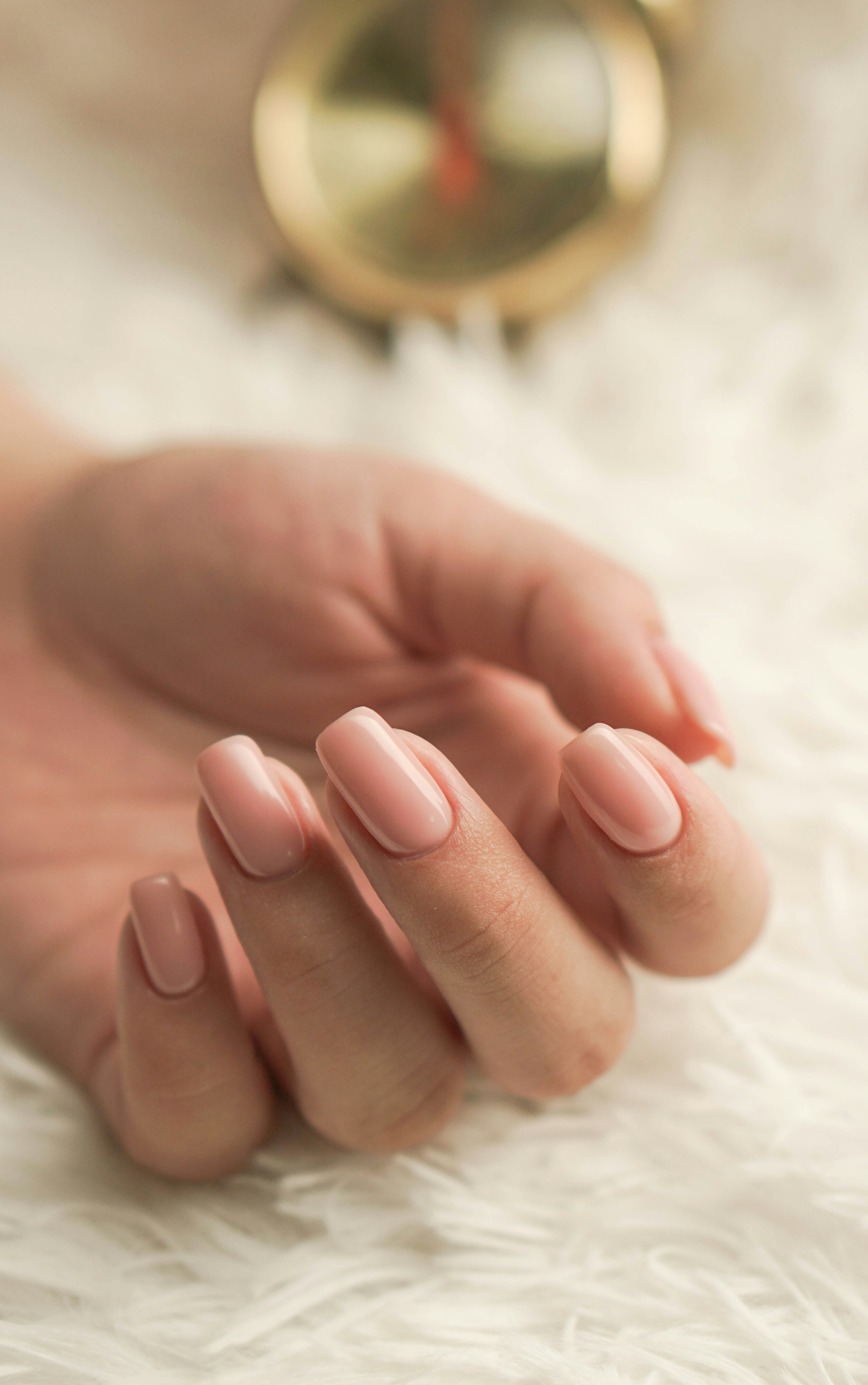 a woman's hand with a pink manicure on it
