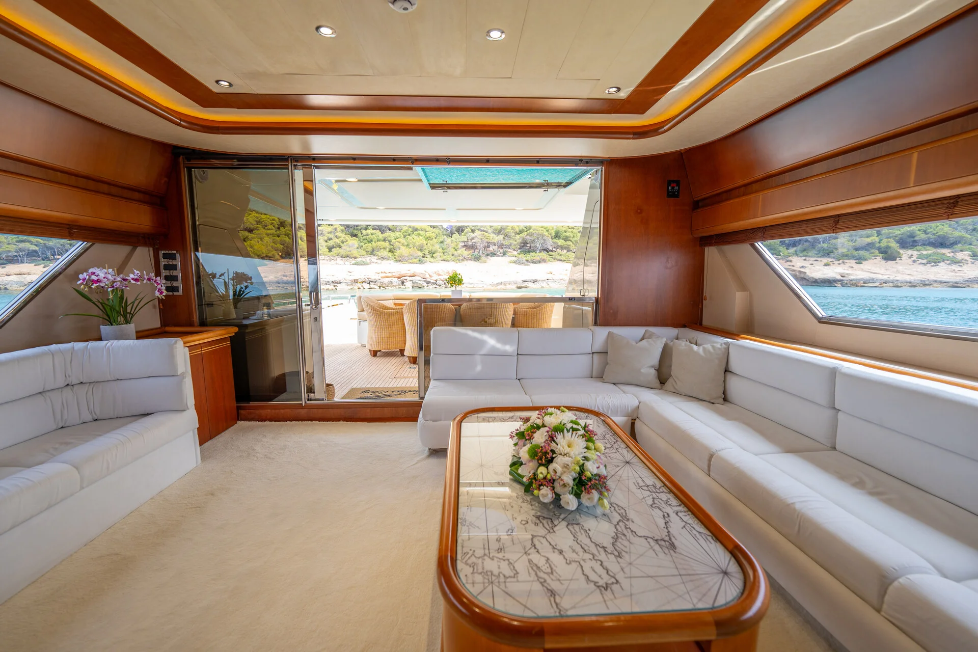 White Rock 36 speedboat with captain at helm cruising calm blue waters near Paros coastline with hills in background.