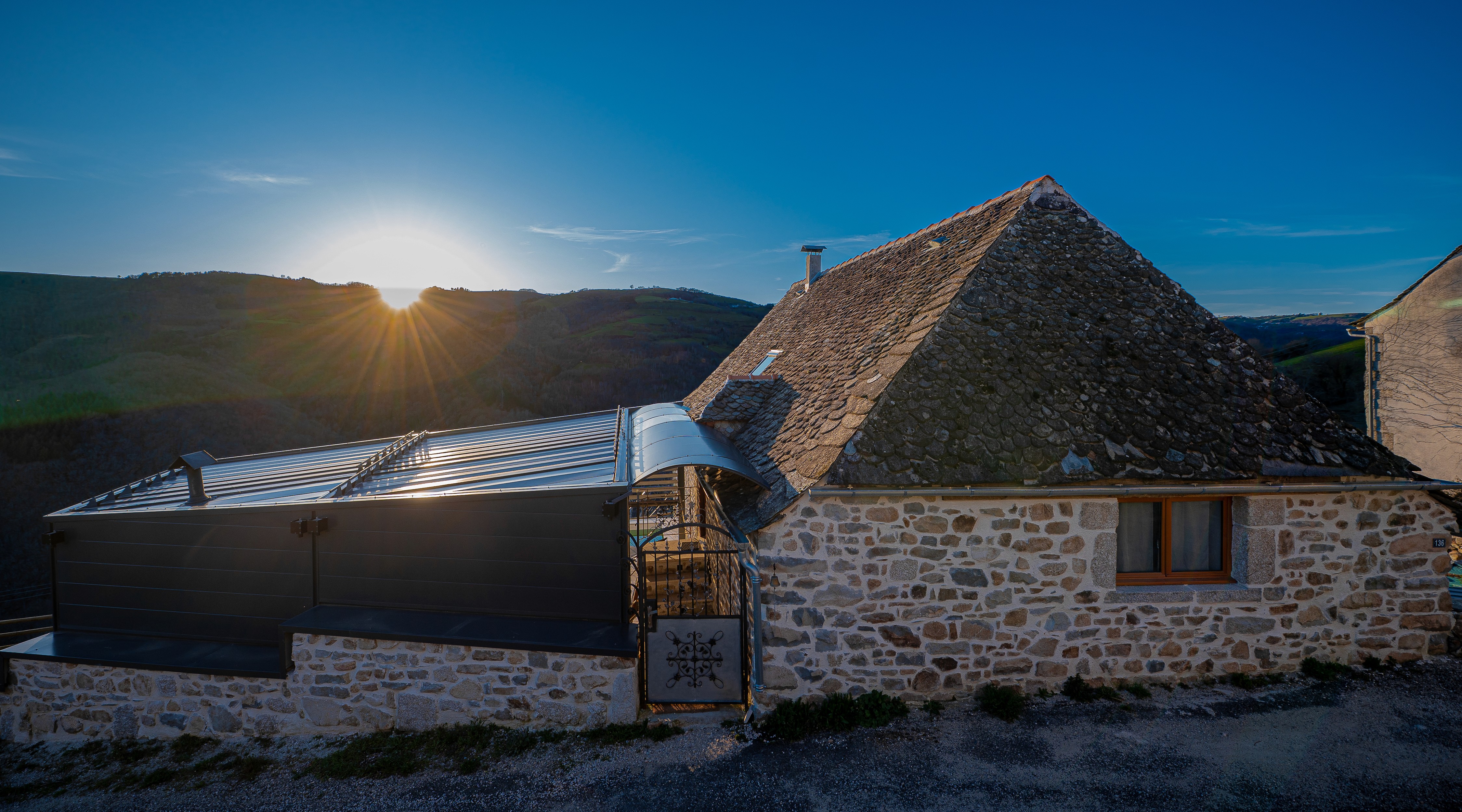 Terrace of Chez Cati with seating area, pool and flowers overlooking the countryside