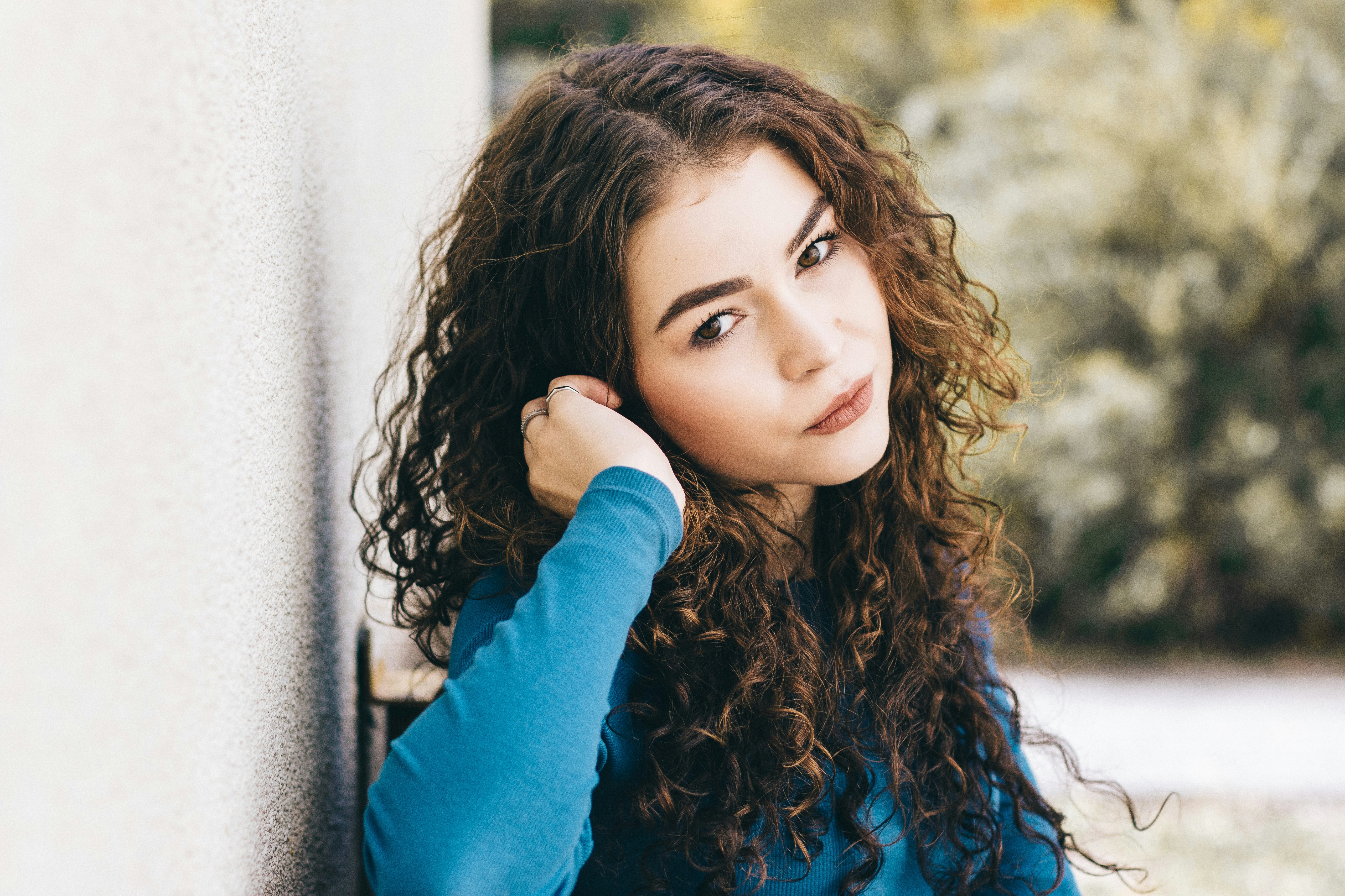 woman with curly hair looking happy - Best Clothing Colors for Fair Skin