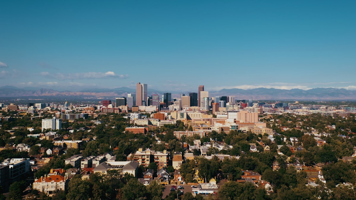 Downtown Denver skyline on a clear summer day with Colorado Rocky Mountains in the distance