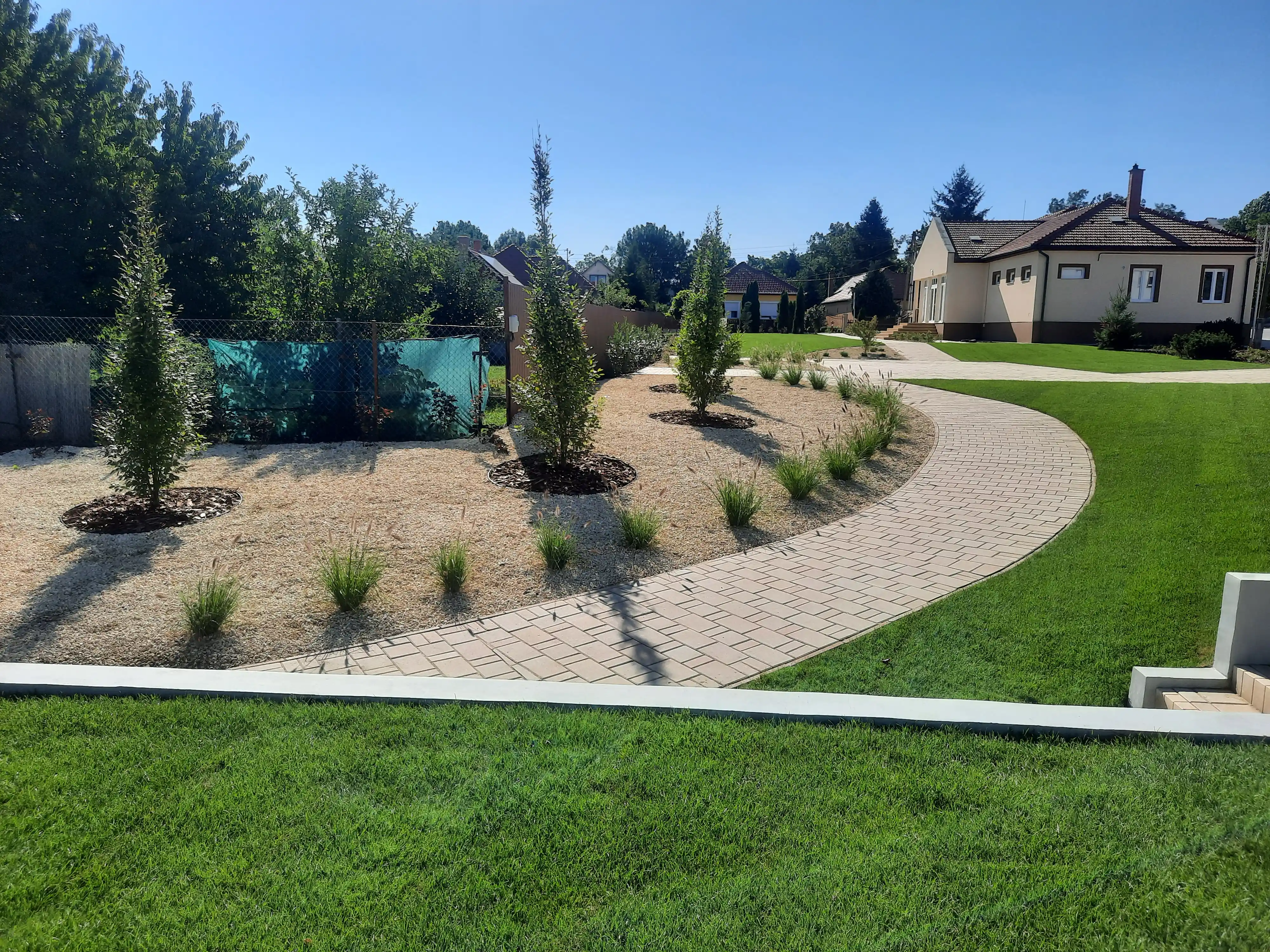 Díszgyep telepítés köztéri parkban kanyargó járdával