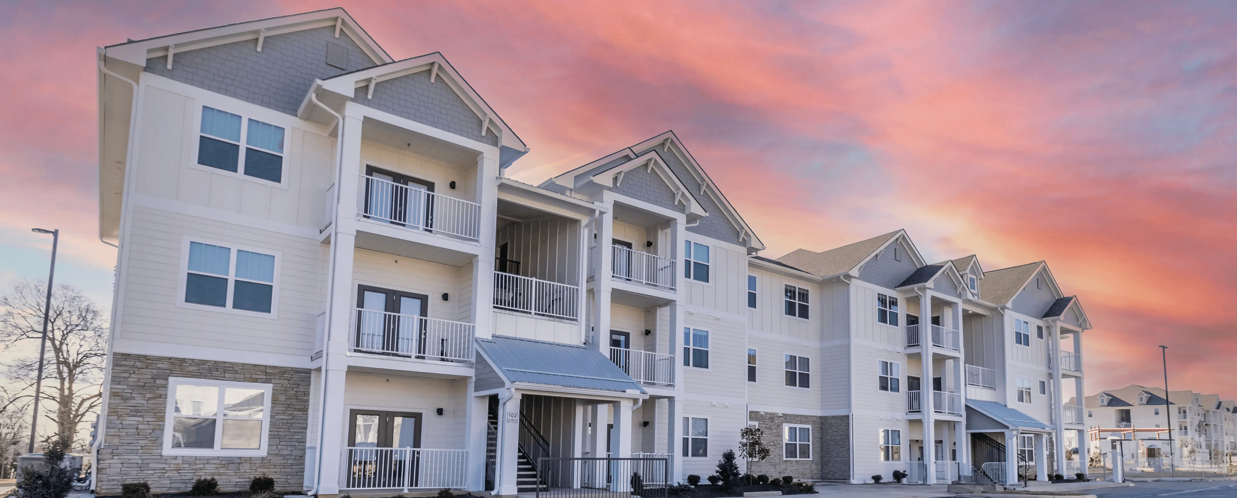 Apartment building exterior with private balconies at sunset at The Reserve at Cool Springs, Elizabethtown, KY