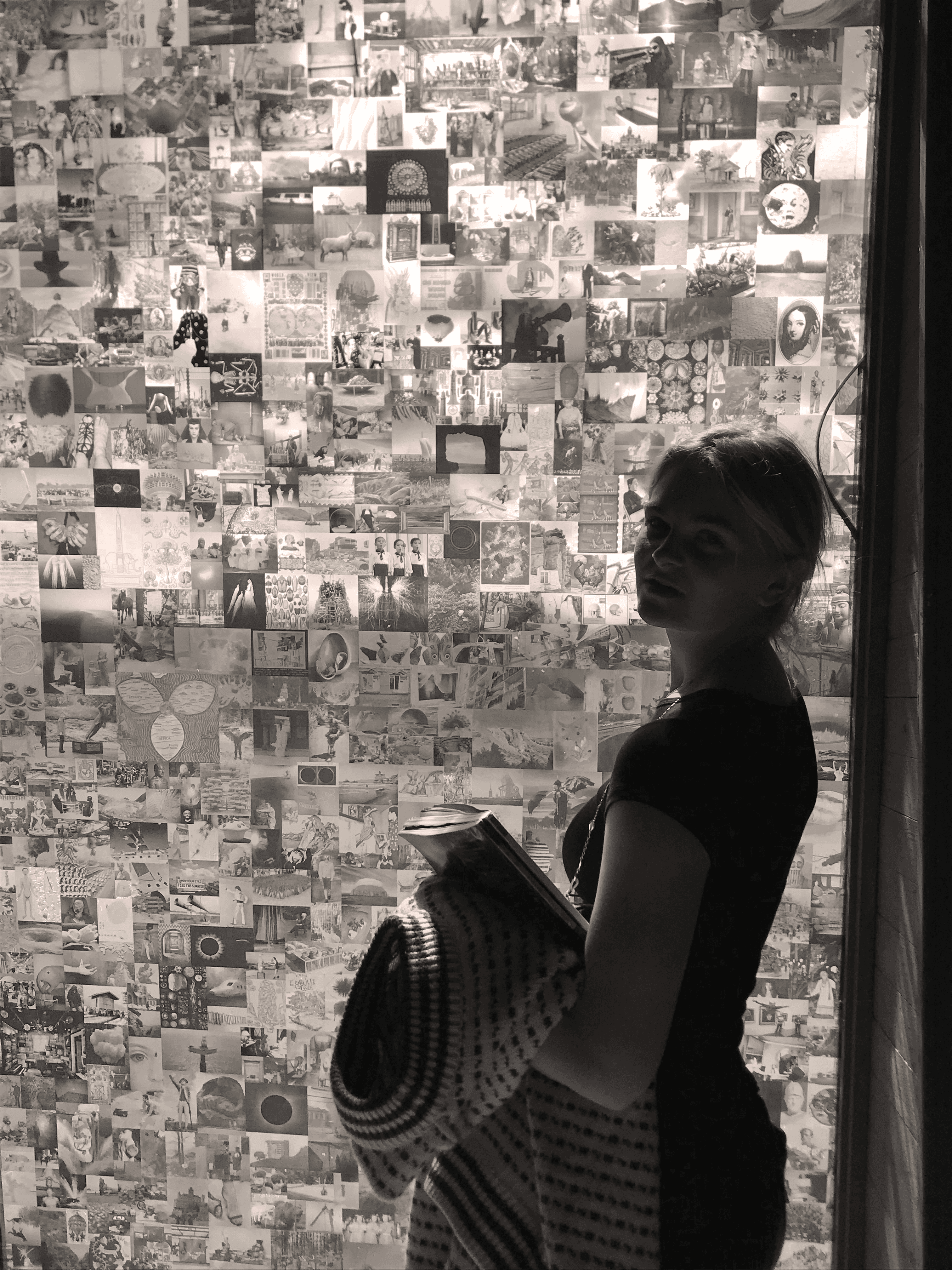 A close-up of a hand wearing multiple decorative rings against a blue background.