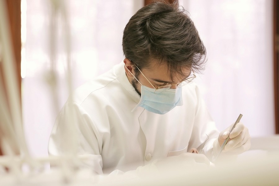 a dentist wearing a face mask treats a patient