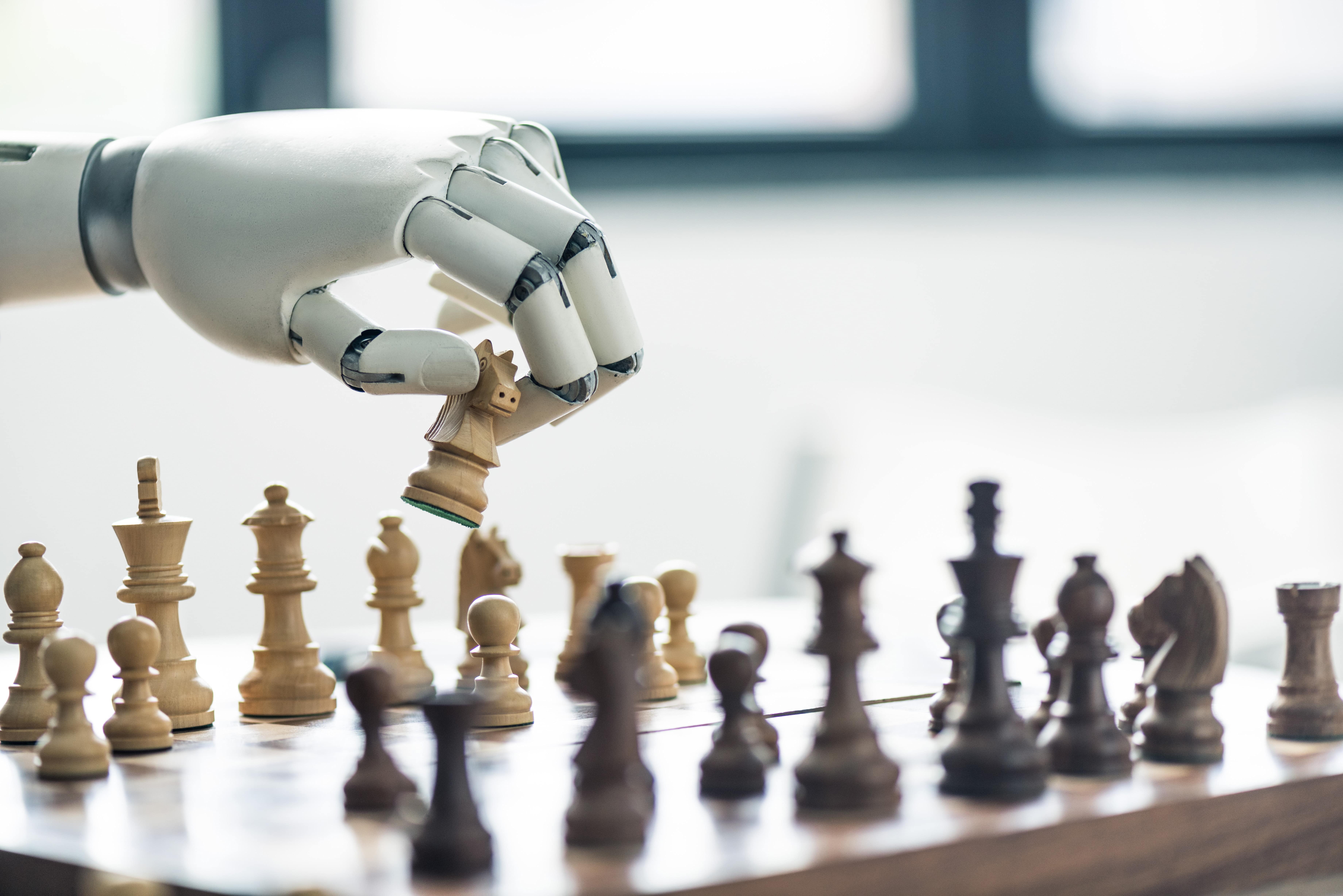 A close-up of a robotic hand making a strategic move with a knight on a chessboard, illustrating artificial intelligence and machine learning in action.