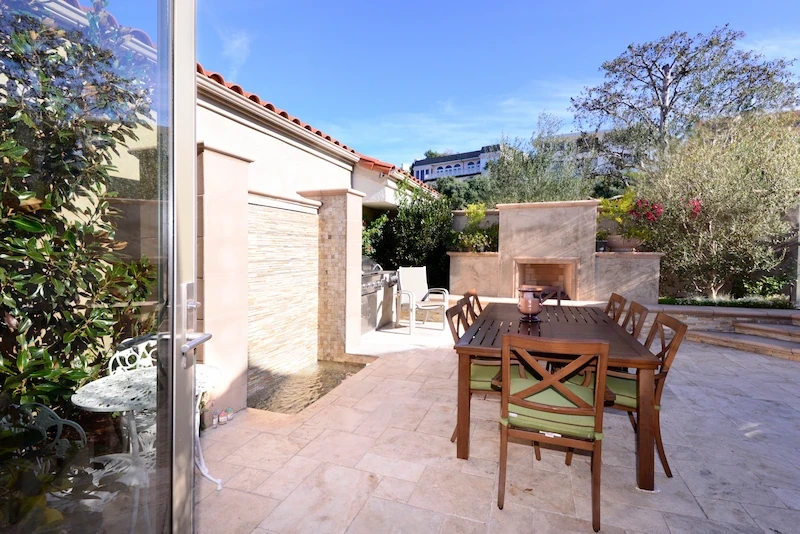 Private master bedroom patio with dining set and stone wall in Harbor Ridge Transitional Remodel.