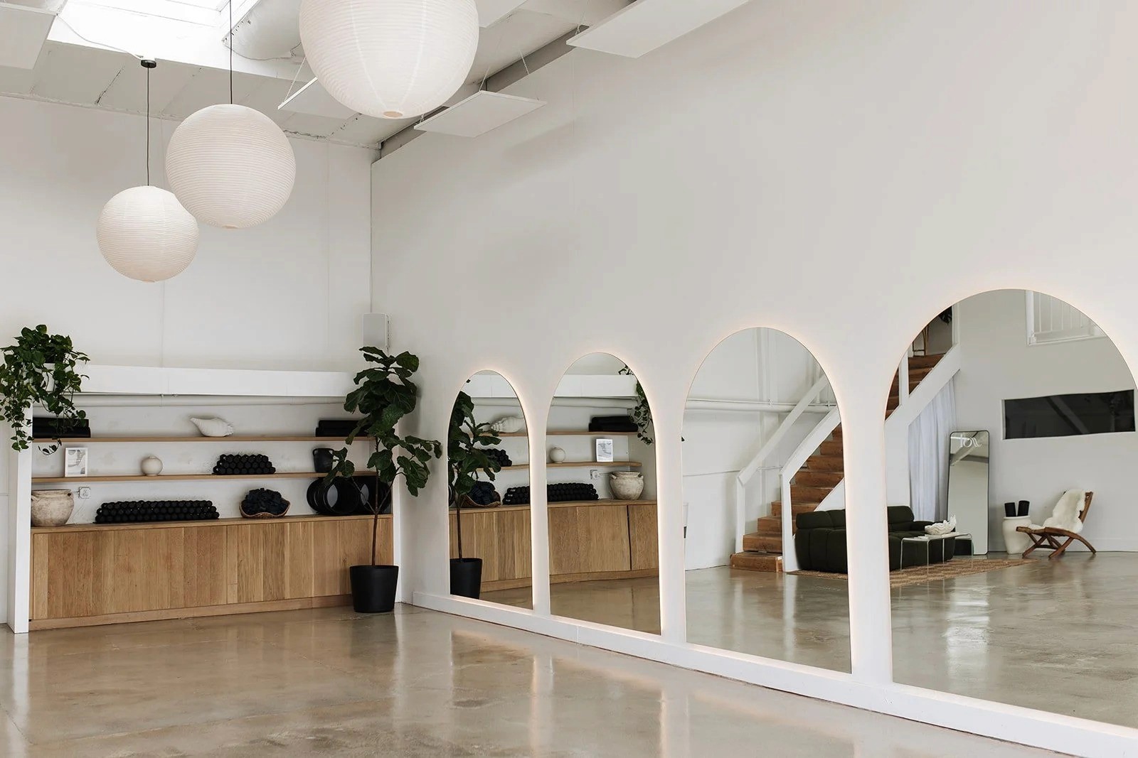 Minimal Pilates studio interior with arched mirrors and warm wood finishes at Ssol Pilates