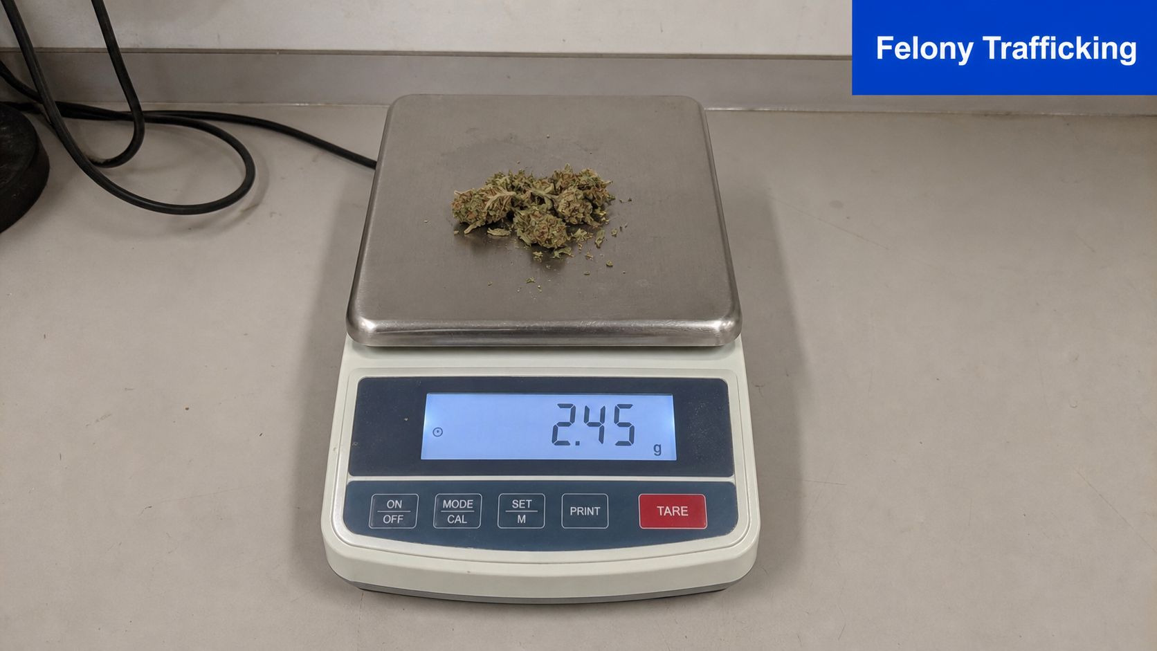 A small amount of marijuana weighing 2.45 grams displayed on a digital kitchen scale.