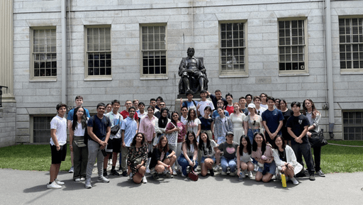 Group photo of 2023 alumnuses in front of the statue