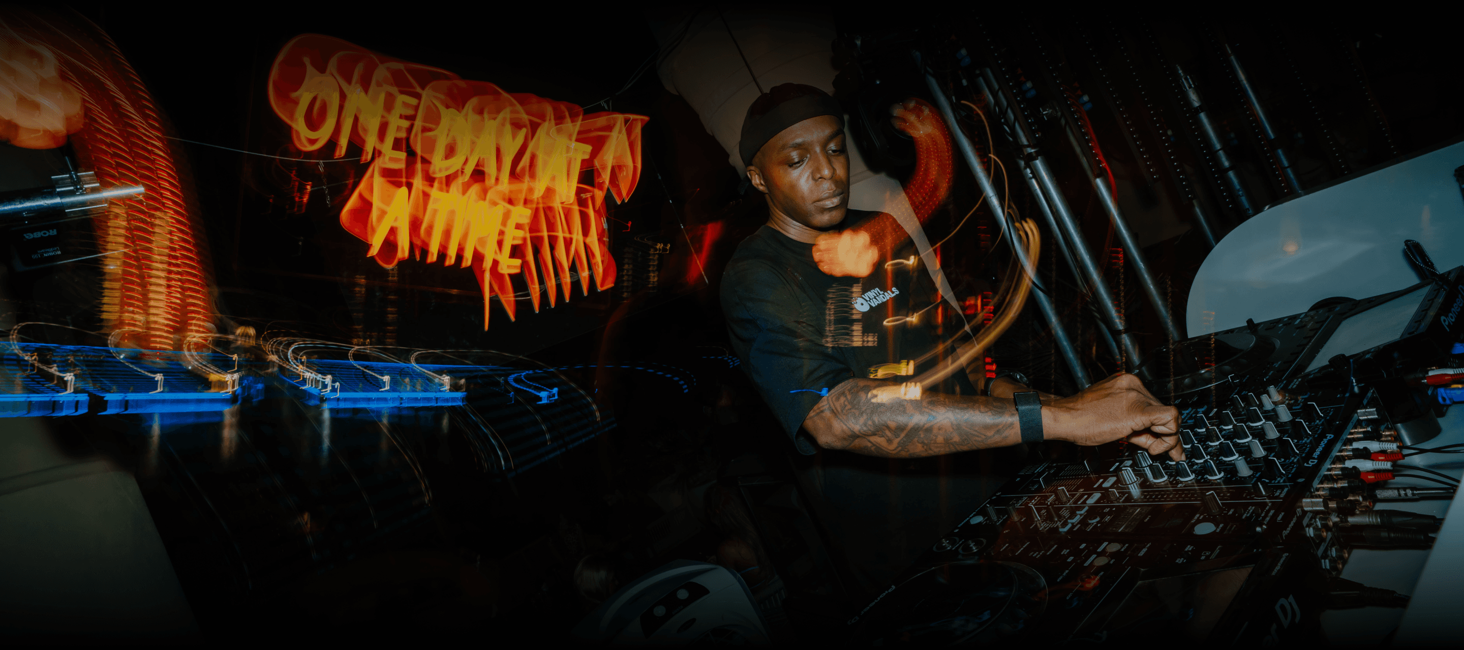 Group of people enjoying ODAAT night event under red lighting and vibrant visuals.