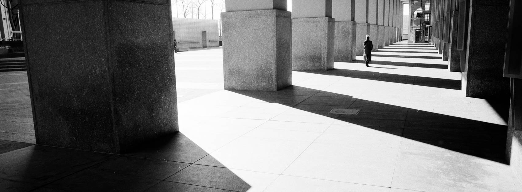 NYC pictures black and white where shadows meet people roaming the city, panoramic Hasselblad XPan workflow moment.