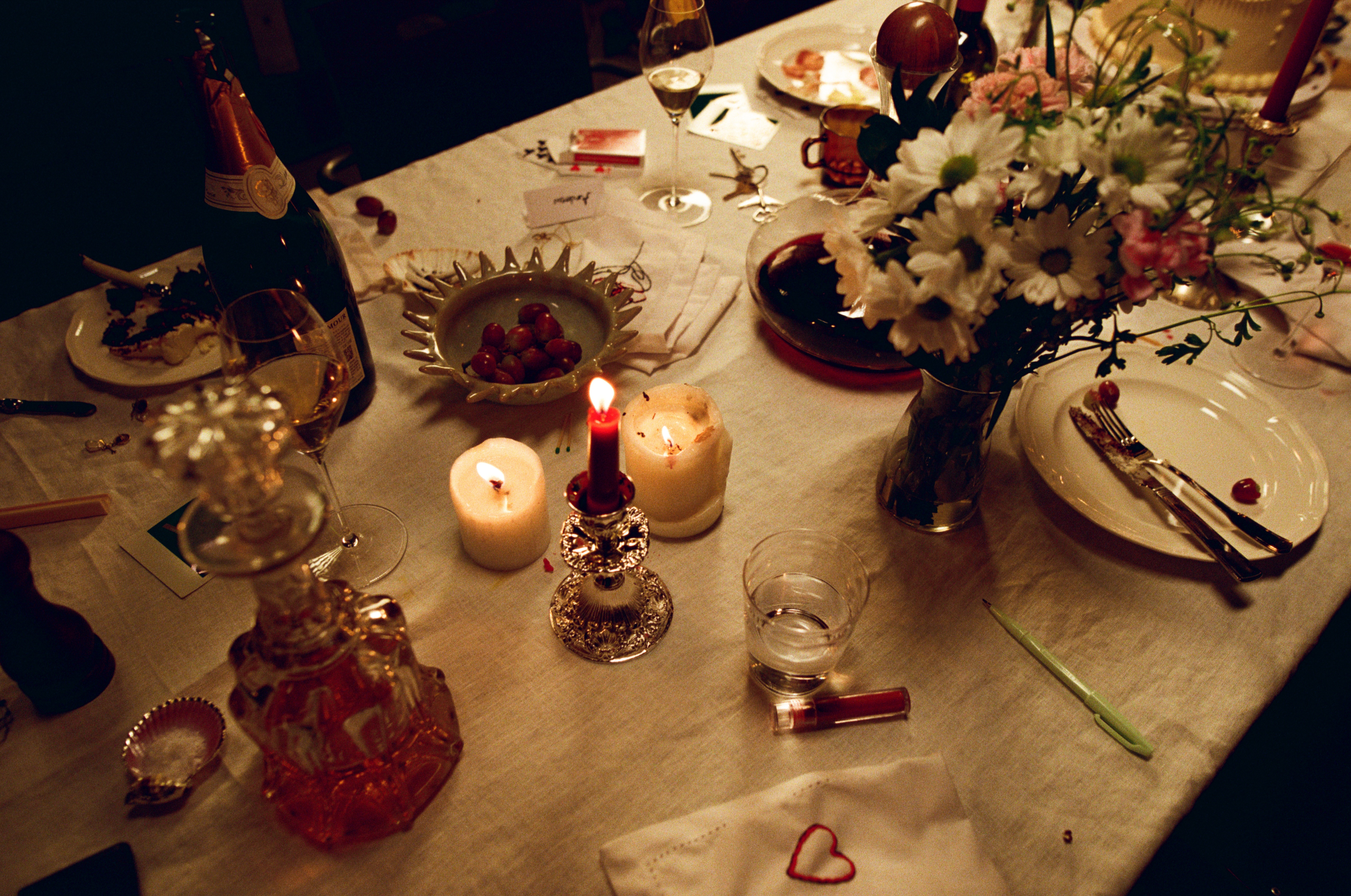 A decorative floral arrangement spills over a table draped in red fabric, creating an elegant atmosphere.