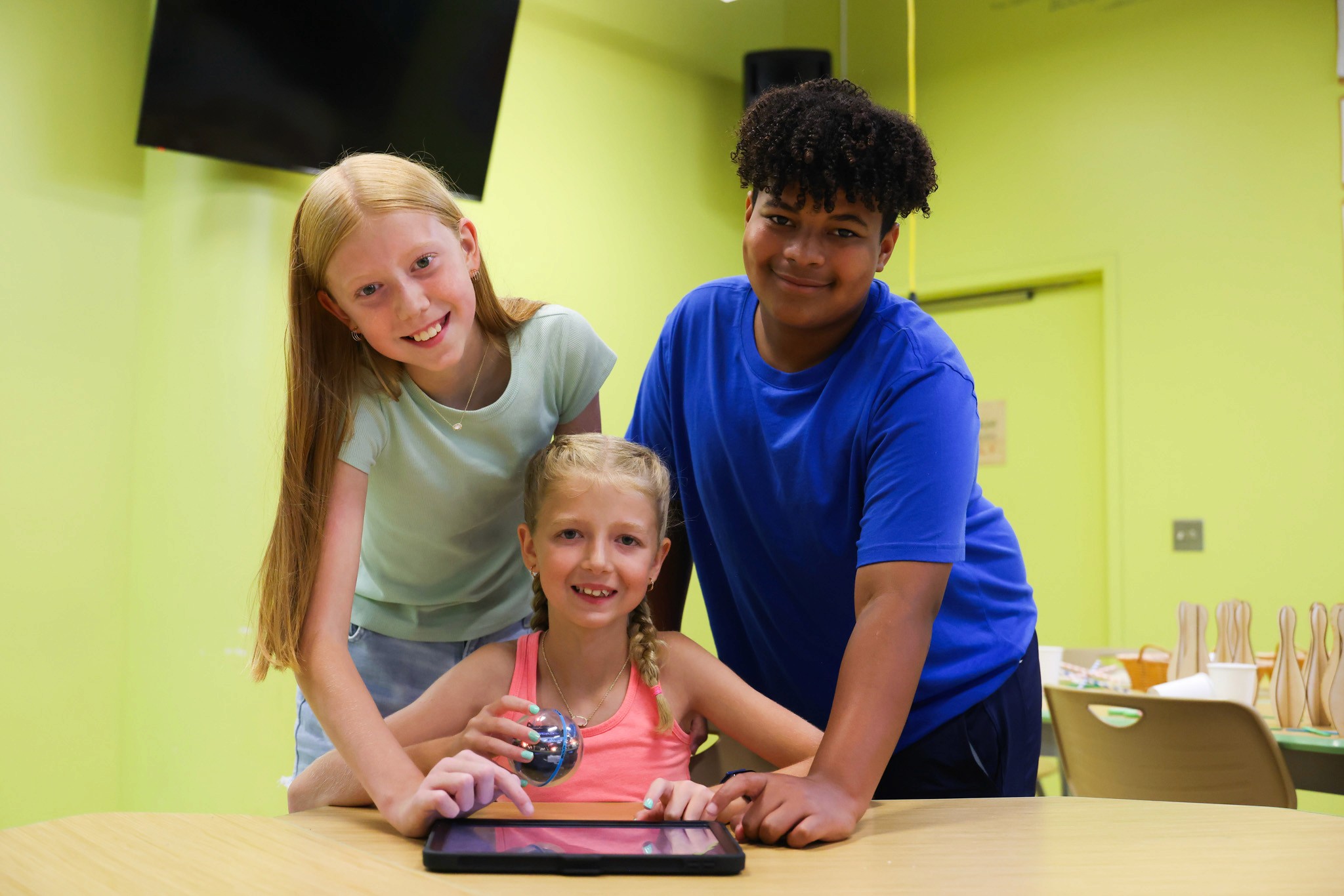 A group of students work together code a robot.