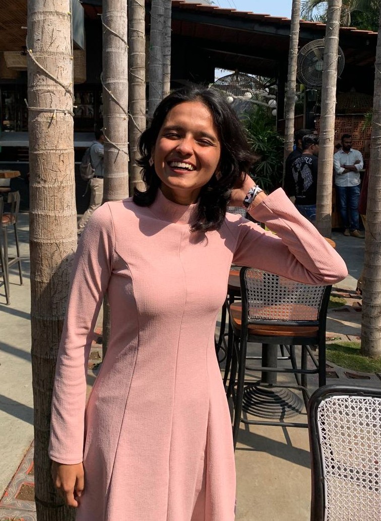 smiling woman sitting on grass during daytime