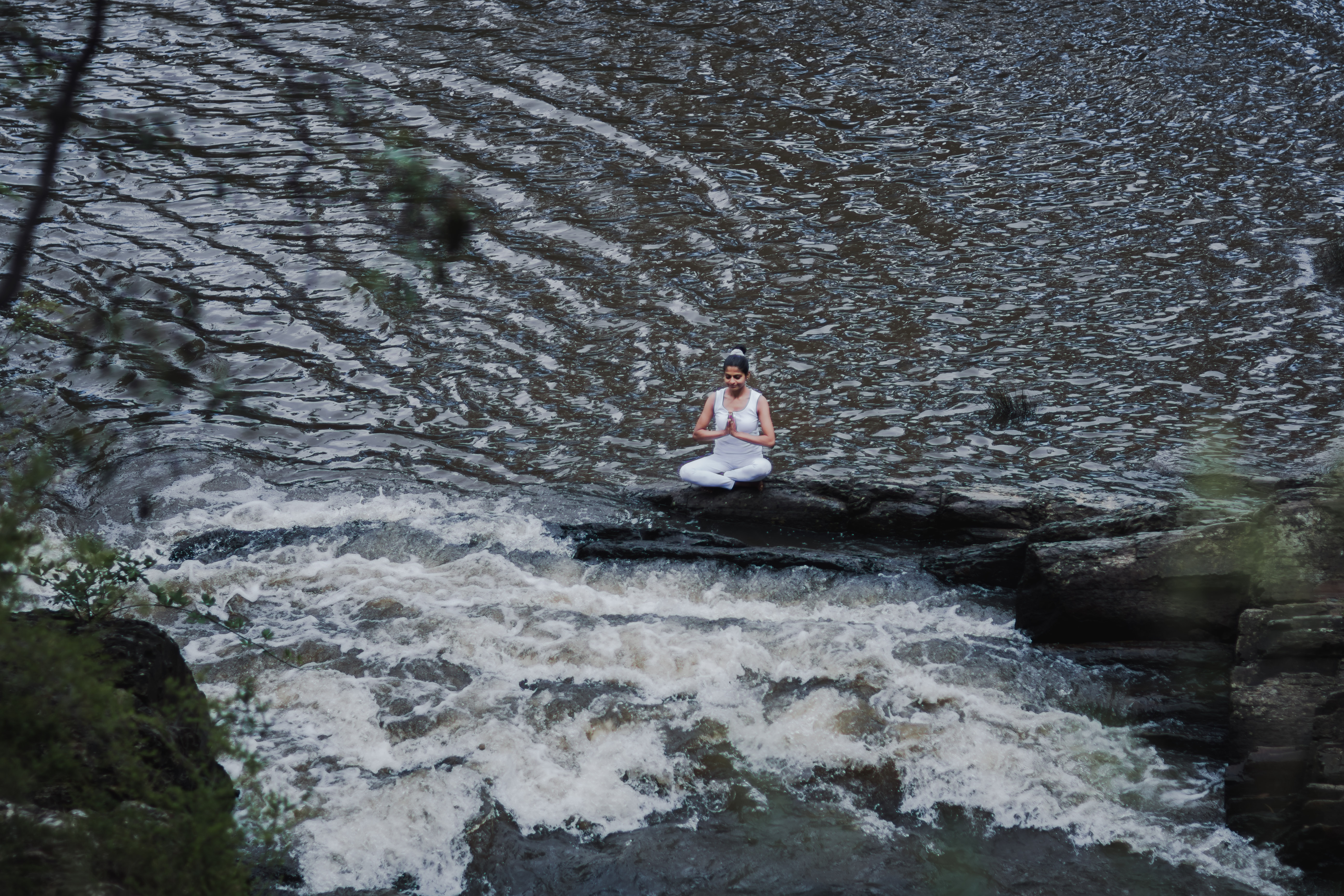 Close-up of a person meditating cross-legged indoors